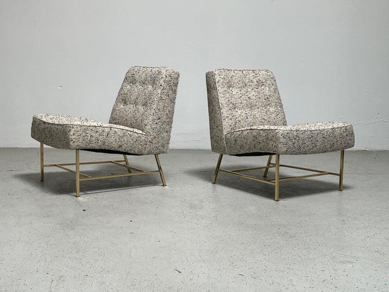 A pair of beautifully restored lounge chairs designed by Harvey Probber. Sculpted seats with tailored buttons and polished brass base.