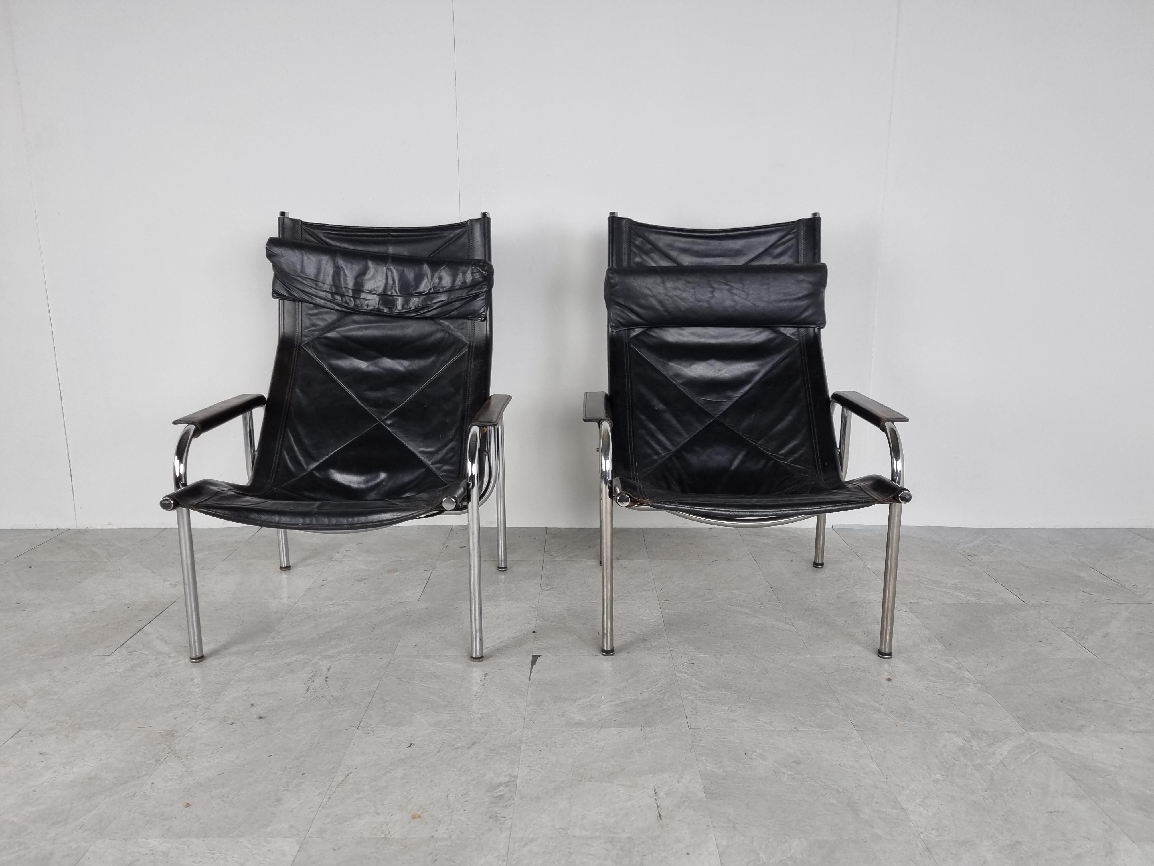 Pair of mid century black leather and chromed tubular metal easychairs designed by Hans Eichenberger and produced by Strassle international.

Beautiful timeless design.

Very good condition with normal age related patina

The Swiss