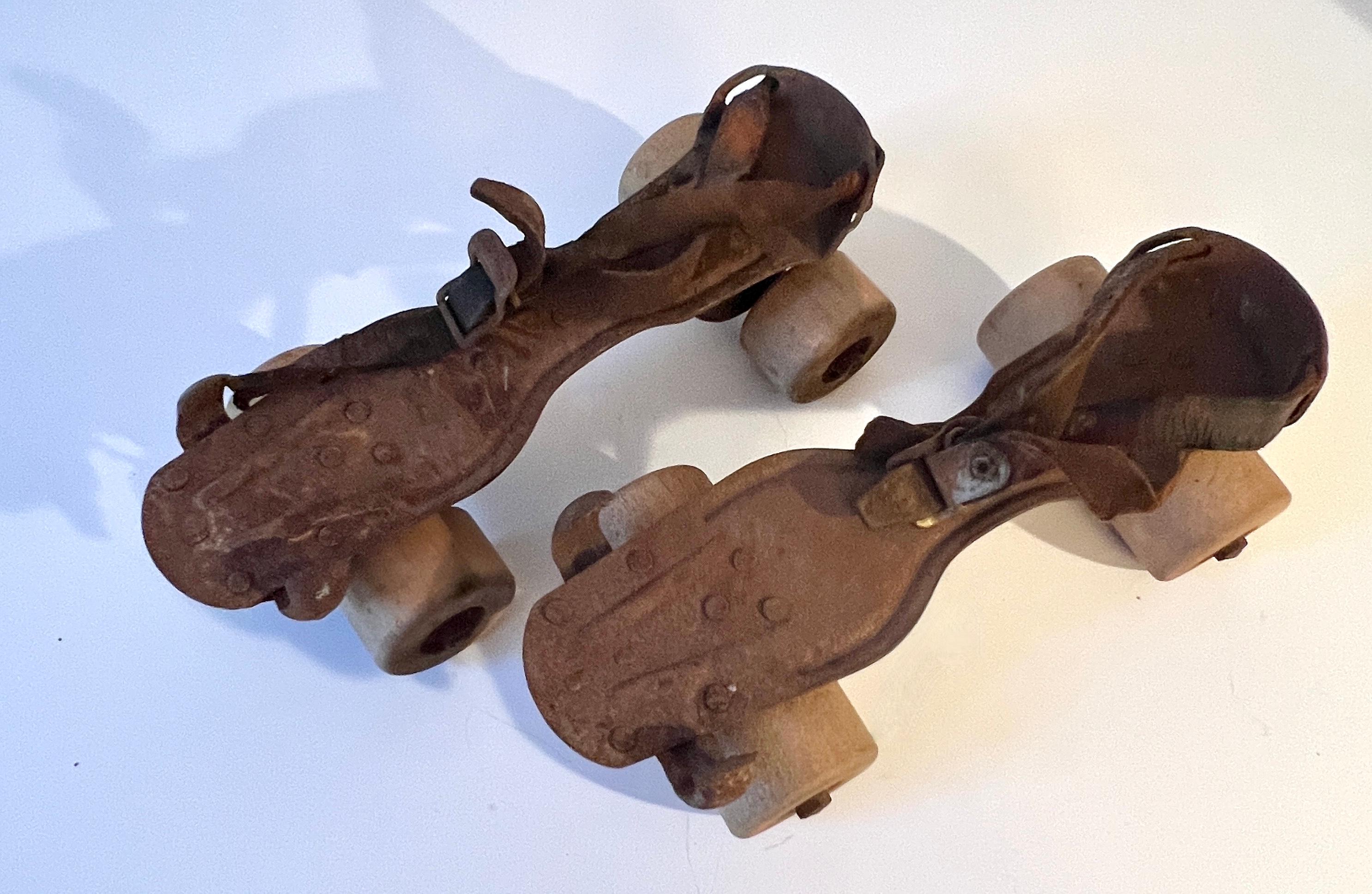 Patiné Paire de patins à rouleau en métal et cuir fortement patiné en vente