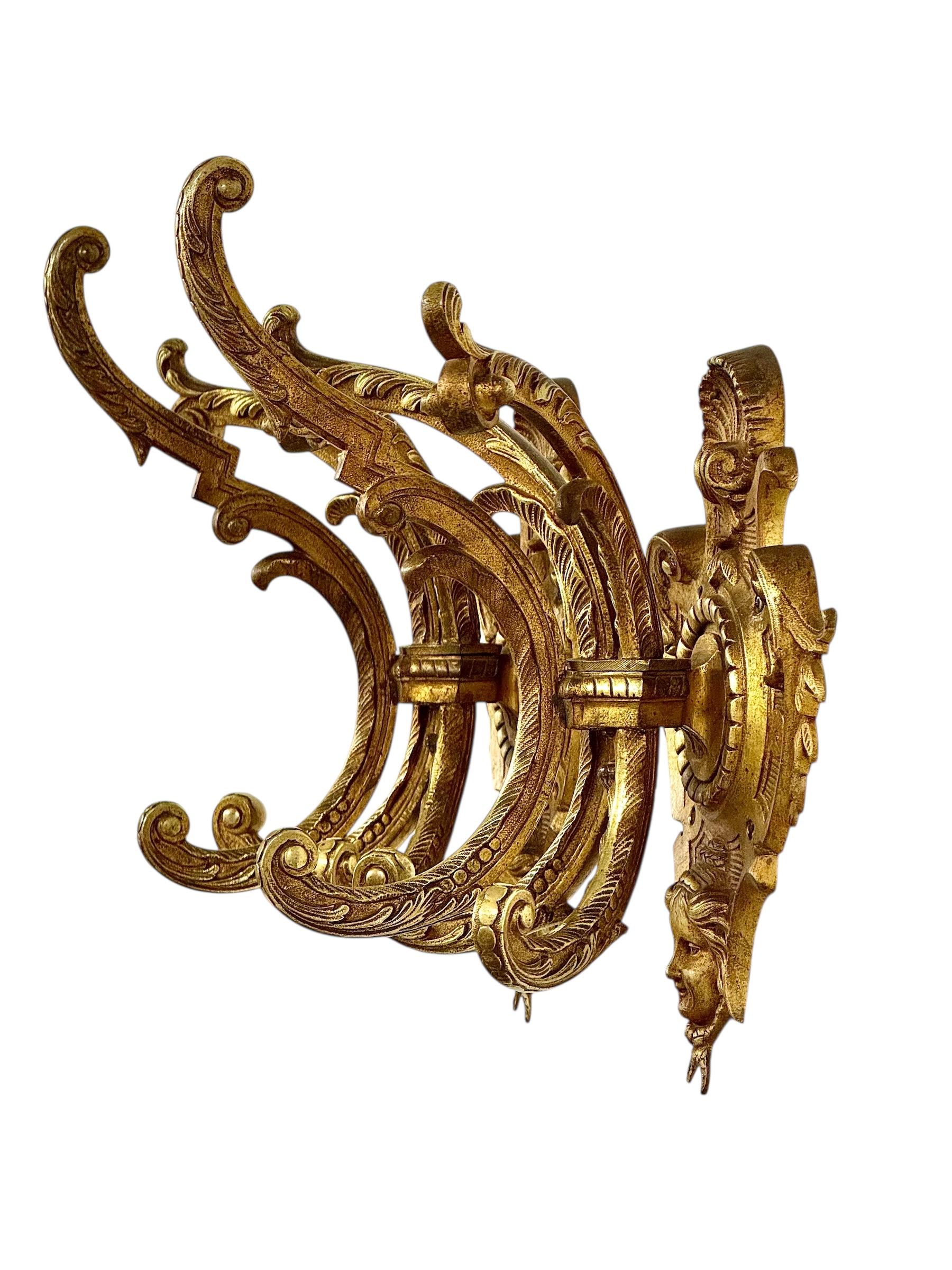 Un'eccezionale coppia di appendiabiti da parete francesi del XIX secolo, realizzati in bronzo dorato con dettagli scultorei e peso imponente. Questi rari elementi architettonici incarnano la grandezza e l'eccesso decorativo del Secondo Impero o