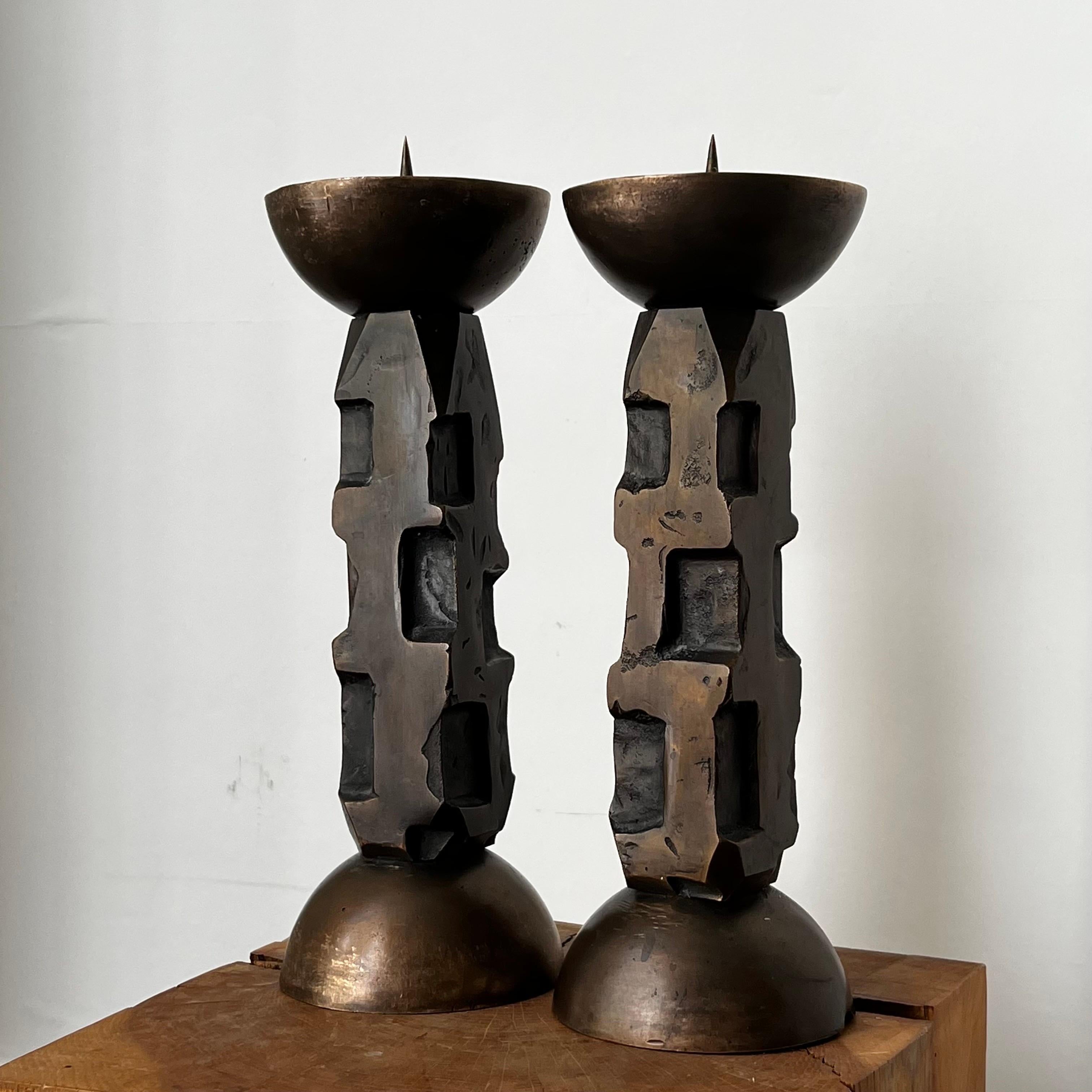 A pair of cast bronze candlesticks, with dark brown patina. European, second half 20th century. 

Heavy sculptural works with the feel of hand-crafted items, each piece slightly different. Former church altarsticks, in good vintage condition with