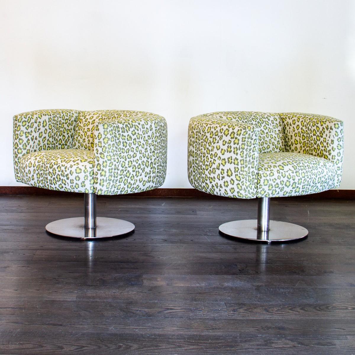 A pair of 1980s, heavy polished steel based, swivel chairs, upholstered in a lime leopard print fabric.