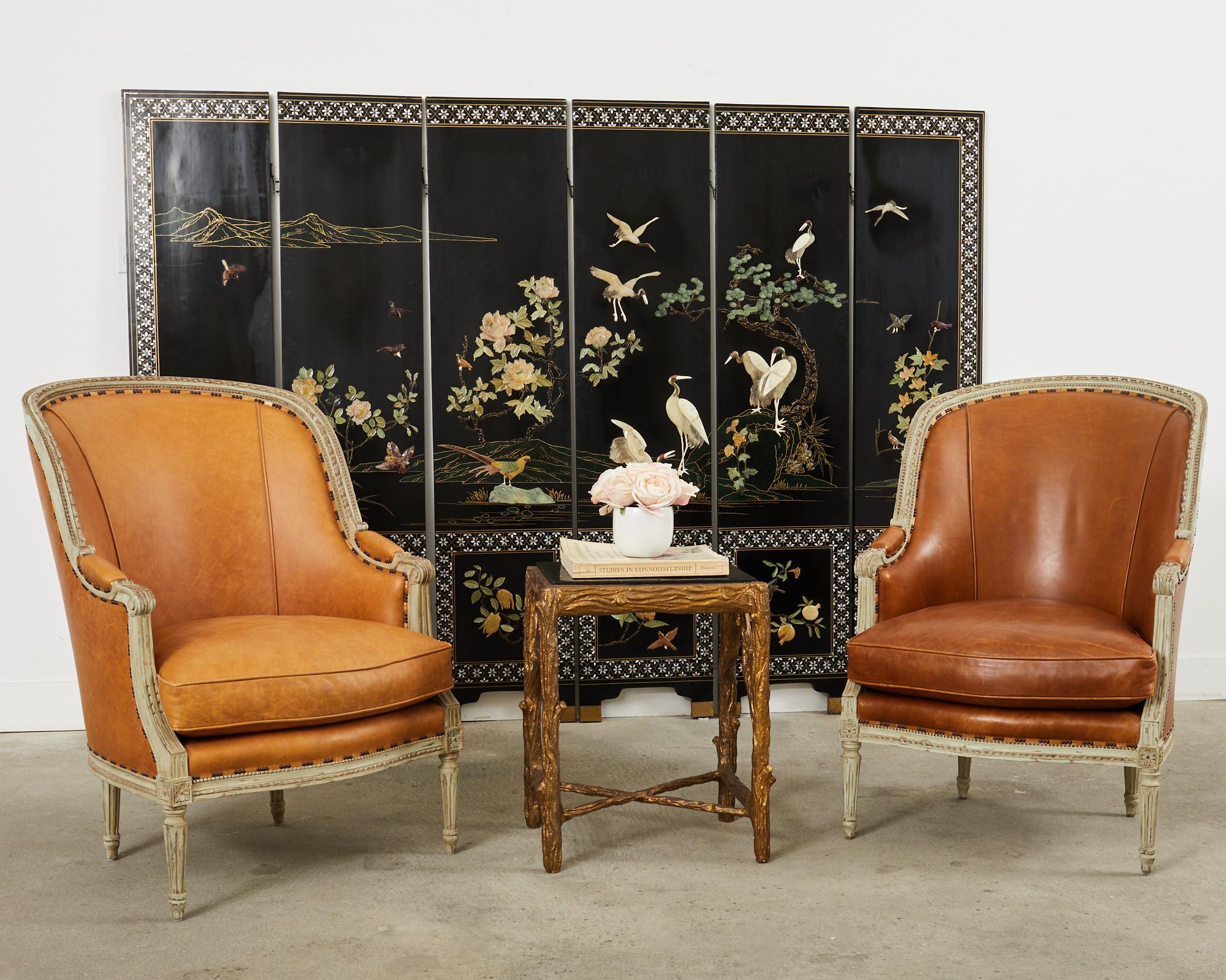 Amazing pair of lounge chairs or Bergere armchairs made in the grand neoclassical Louis XVI taste by Hendrix Allardyce Los Angeles, CA. The chairs feature a carved frame with an intentionally, aged distressed patina on the painted finish. Made in a