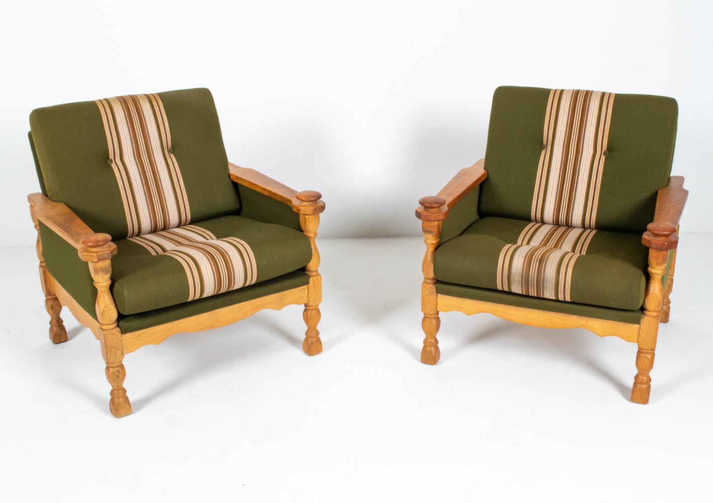 A rare and desirable pair of Danish mid-century lounge chairs designed by Henning Kjaernulf, c. 1960's. Crafted from quarter-sawn white oak, the frames feature sculpted handrests that offer a pleasing tactile experience, a testament to the