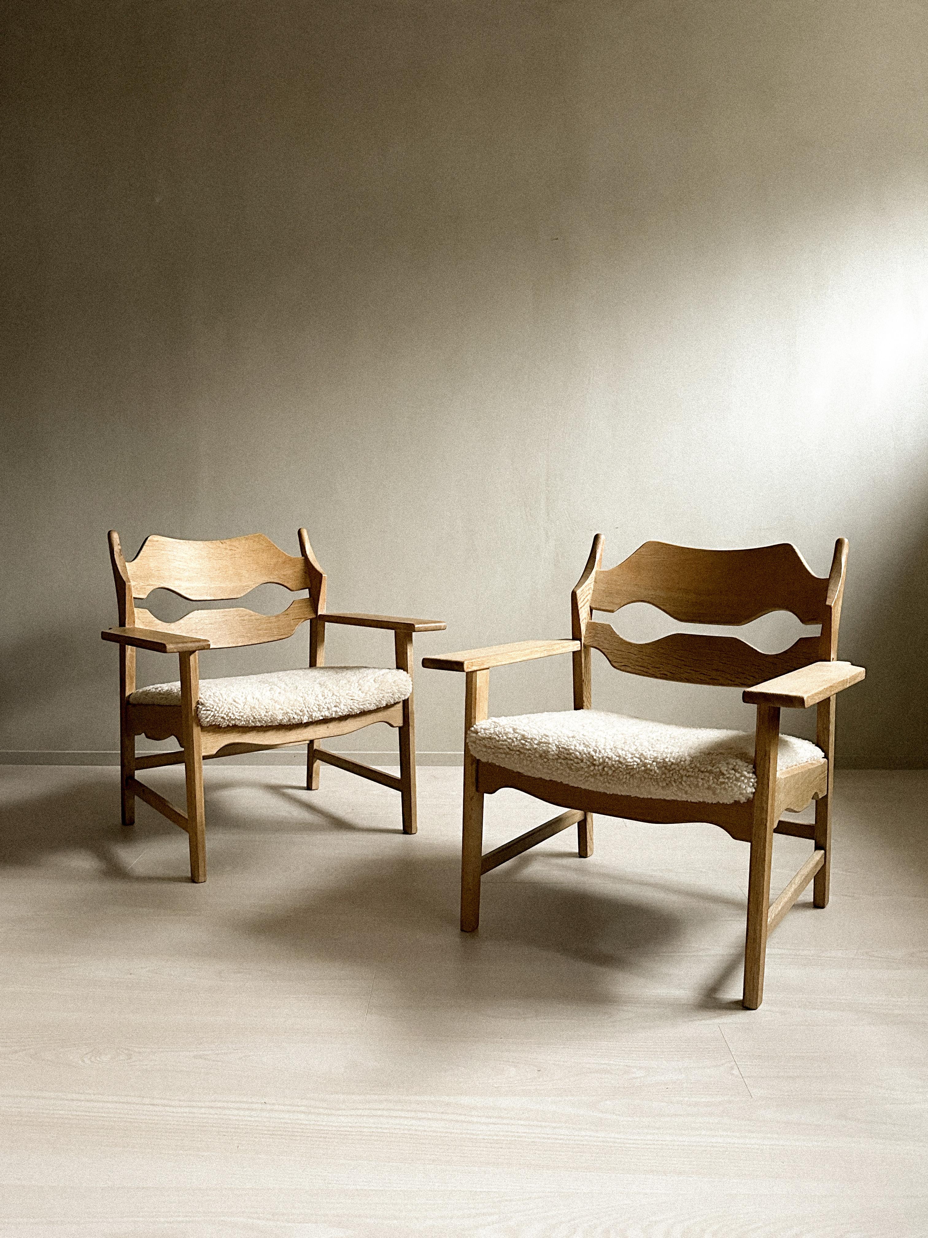 A wonderful set of 2 Razorblade Lounge chairs in oak, designed by Henning Kjærnulf and produced by E.G Kvalitetsmøbel in Denmark in the 1960s. The chairs are recently been professionally reupholstered. 

