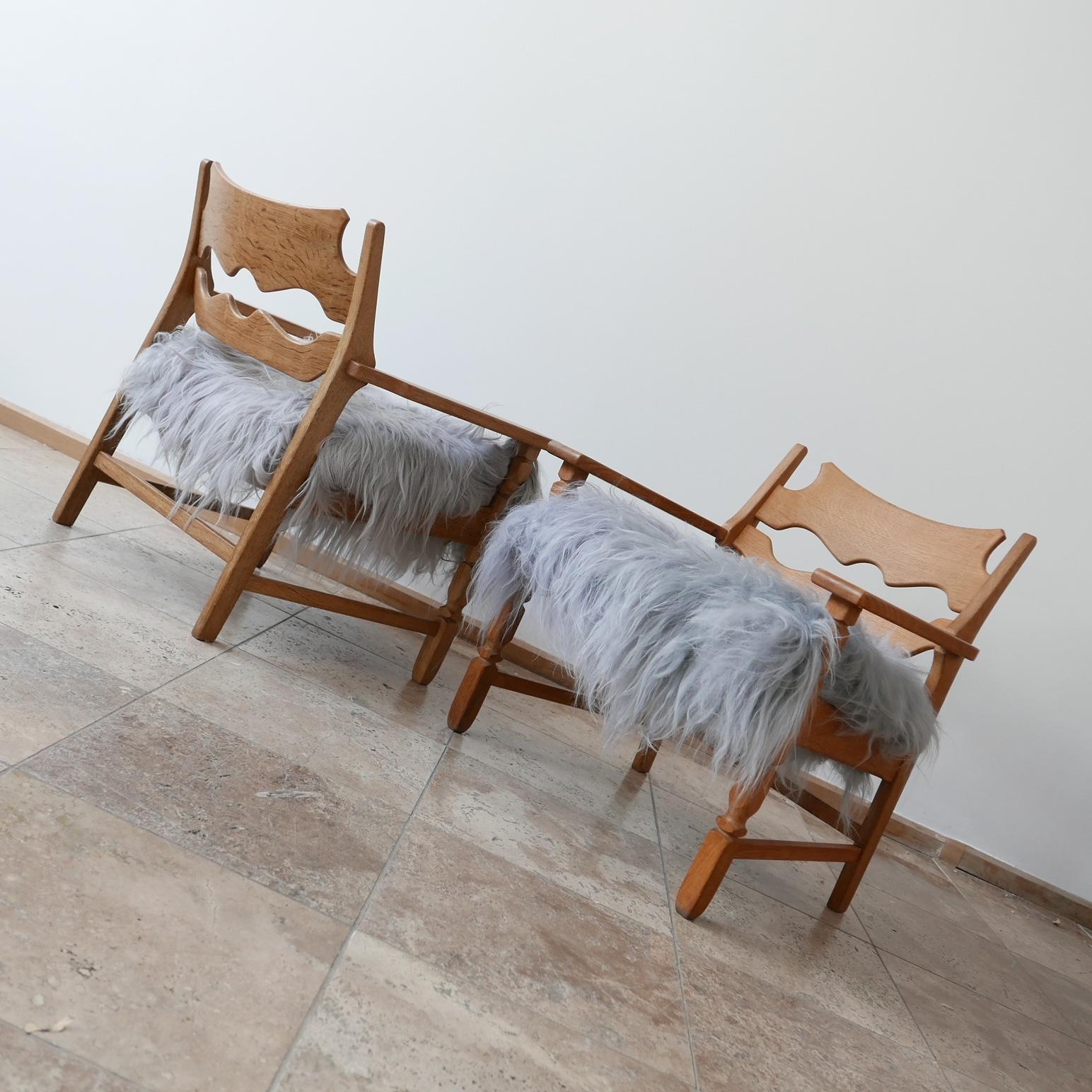 A pair of Henning (Henry) Kjaernulf armchairs.

Denmark, c1960s.

Solid oak, with new upholstered icelandic sheepskin covers.

Small tonality differences between the wood and sheepskins on the two chairs but fractional.

We may split, but priced and