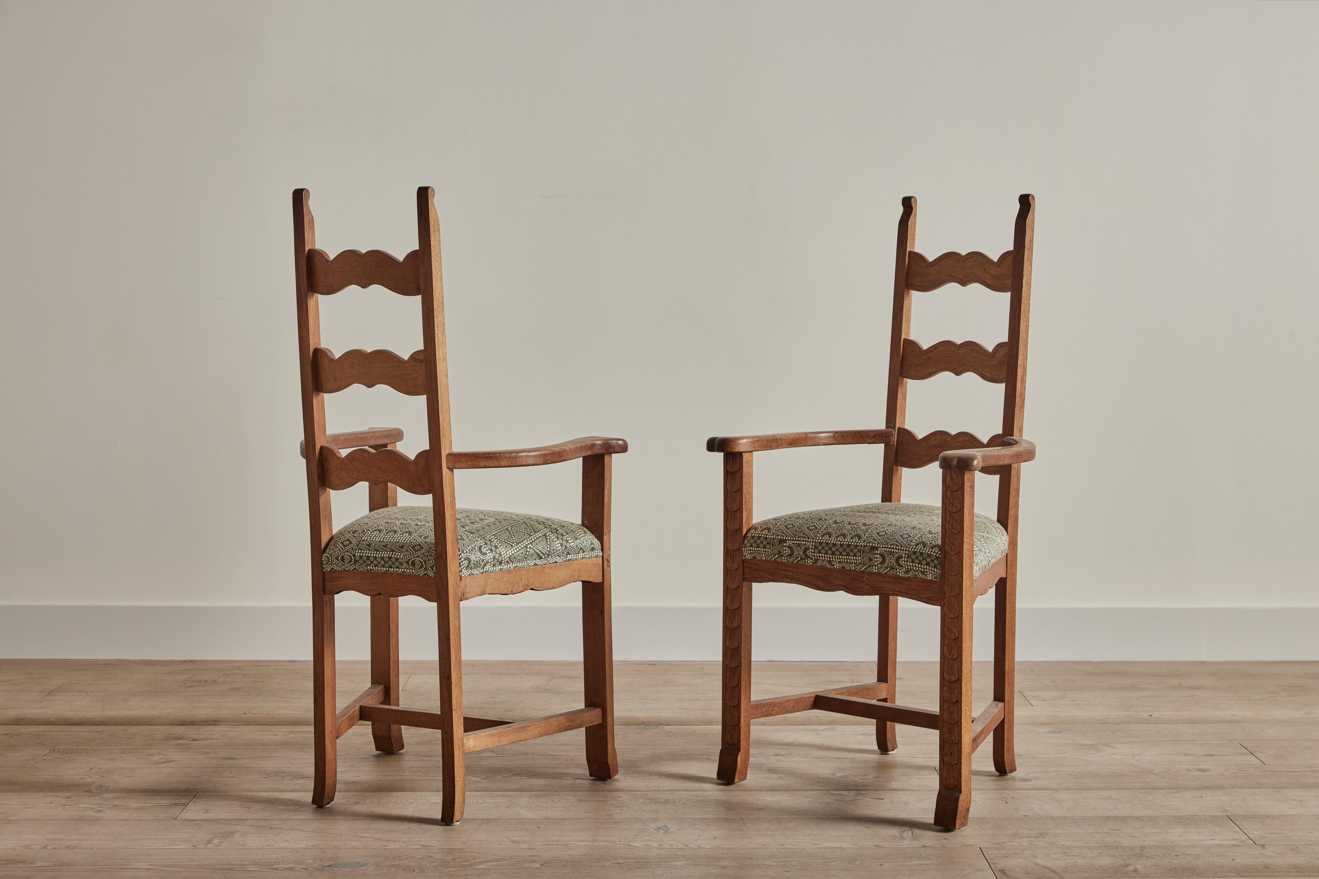 Pair of carved oak wood armchairs attributed to Danish designer Henning Kjaernulf circa 1960. Seats are newly upholstered in Susan Deliss weave in Batik Moss.