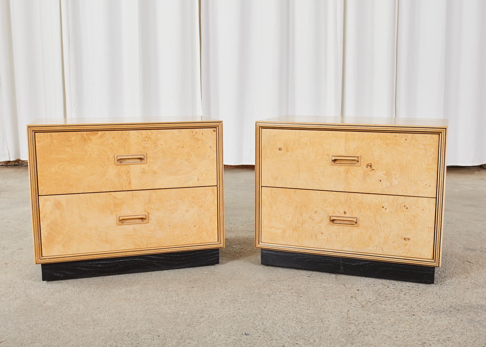 Stunning pair of low bachelors chests or nightstands made by Henredon's Scene Two collection. The chests feature a burl olive wood on the front of the drawers and an ash hardwood case finished in blonde. The nightstands are mounted to an ebonized