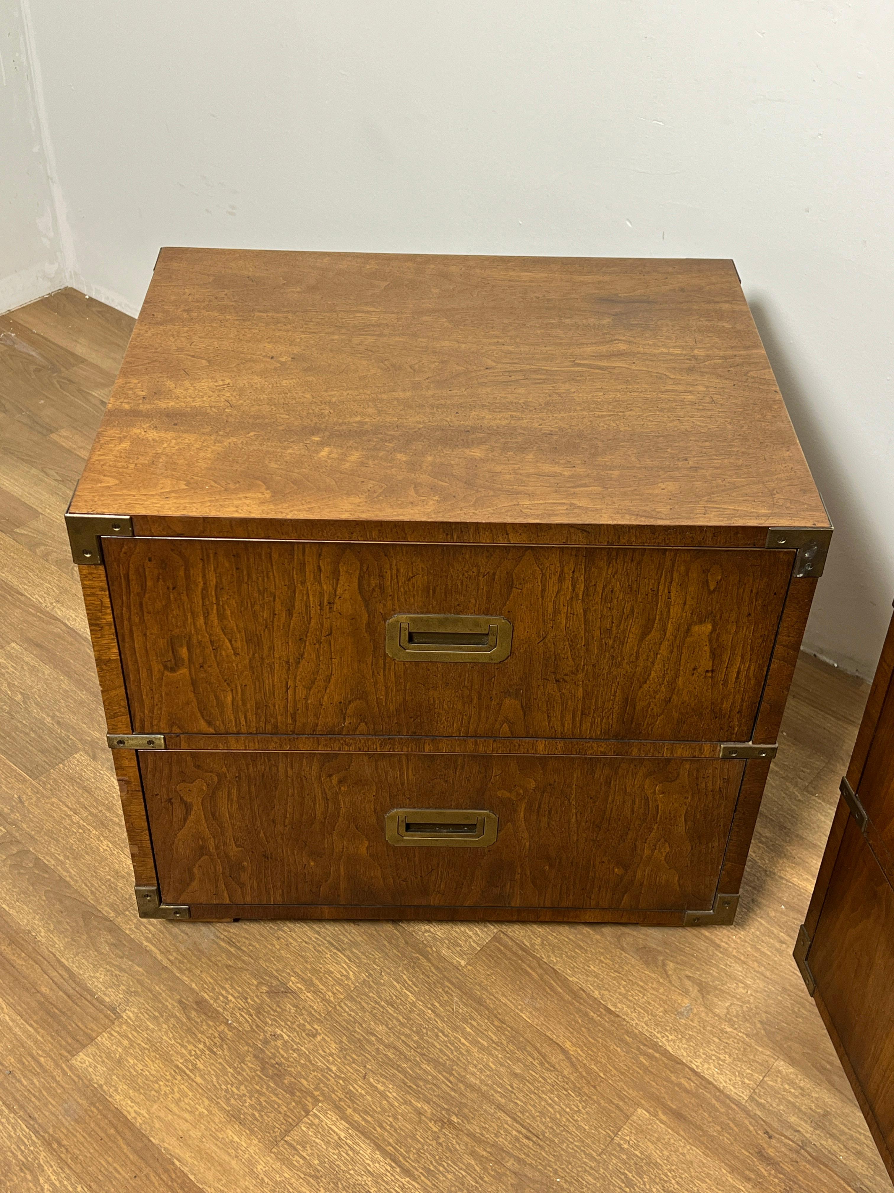Pair of two drawer chest end tables in the campaign style with brass accents and handles, by Henredon, Circa 1970s.  Feet are removable, designed so that one chest can be stacked upon the other if desired.