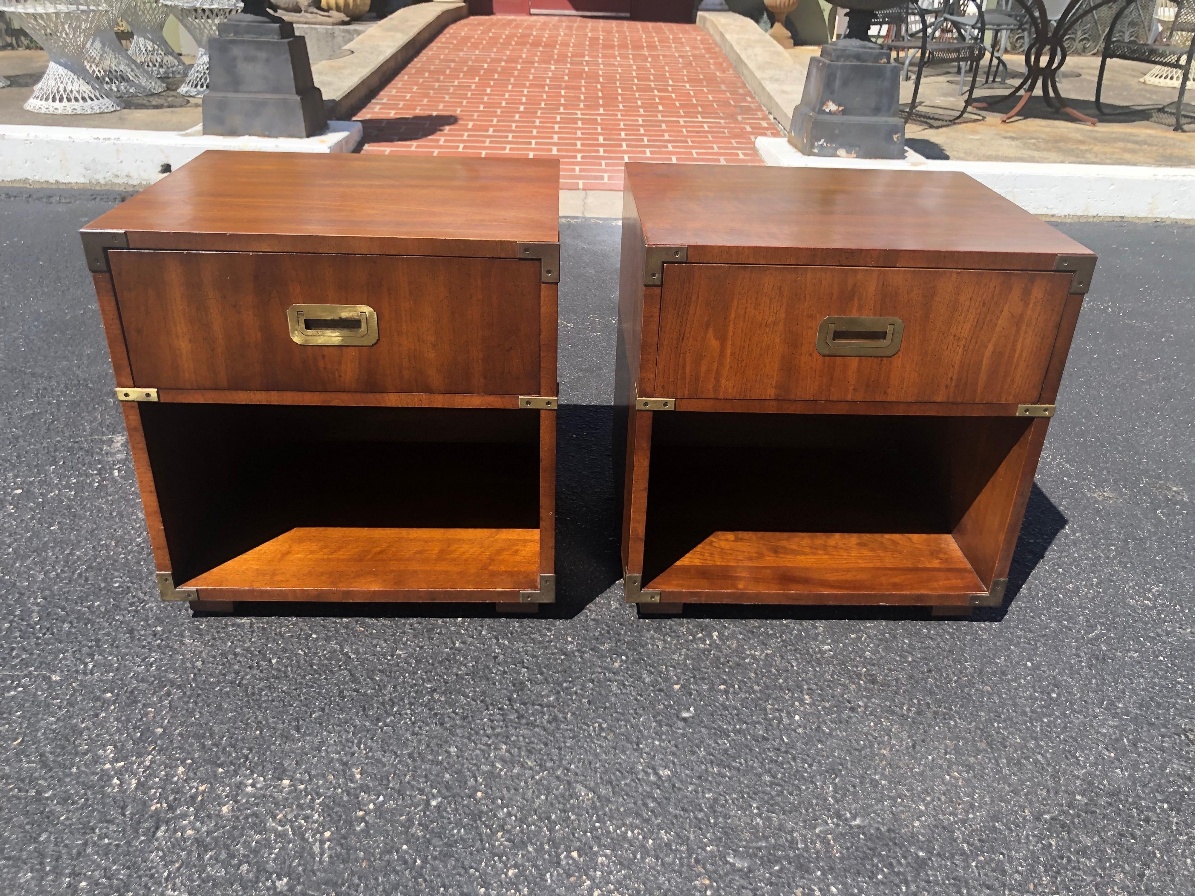 Pair of Henredon Campaign nightstands in walnut. Classic design with nice brass hardware, Single top drawer with open cabinet shelf base. Hard to find these beauties.