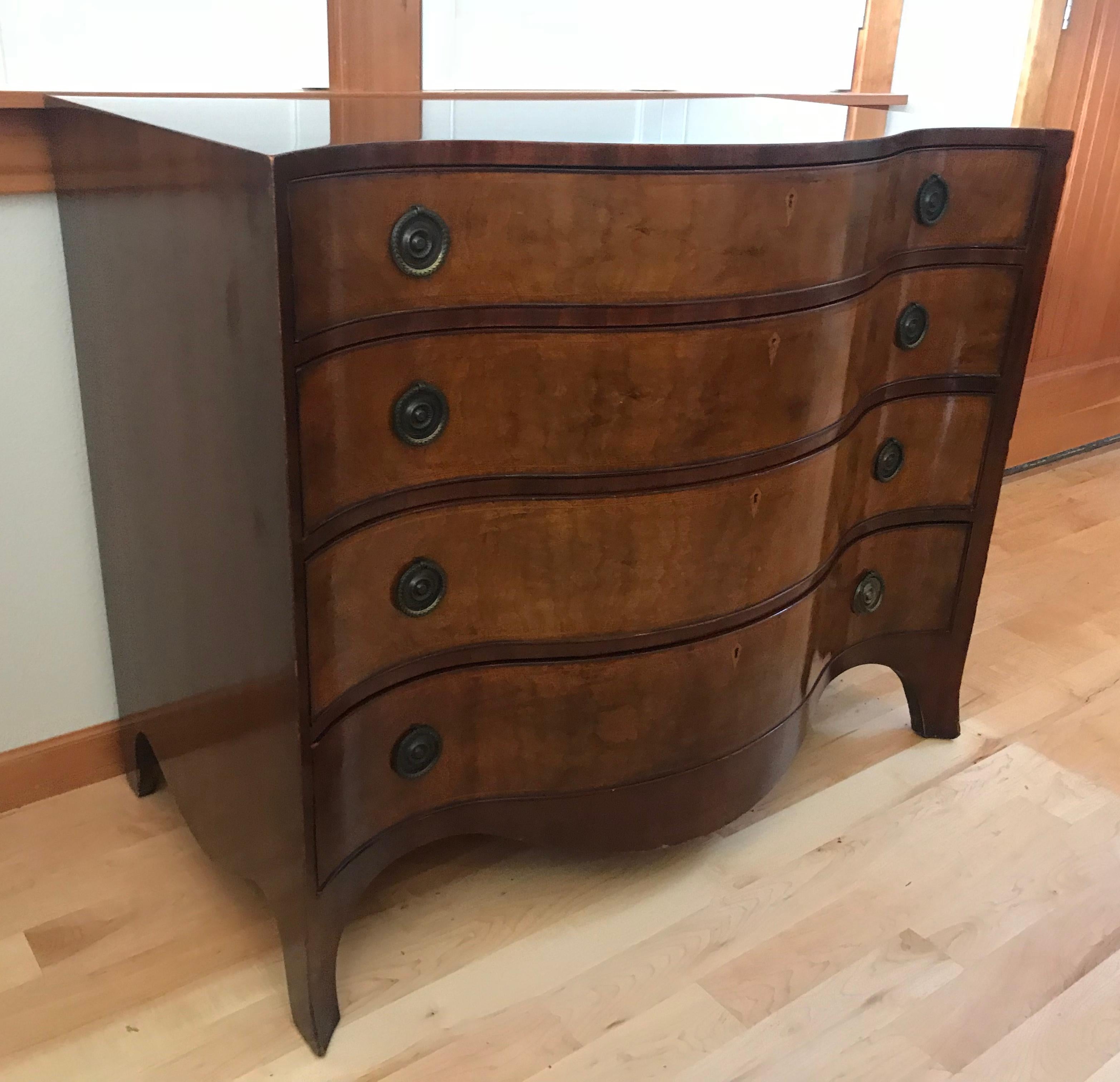 A  highly sought after set of two matching Hepplewhite wavy front chest of drawers of Mahogany with satinwood and rosewood lines inlays and ringed aged brass pulls. Four large drawers each and with splayed feet. Based on an English design of 1785.