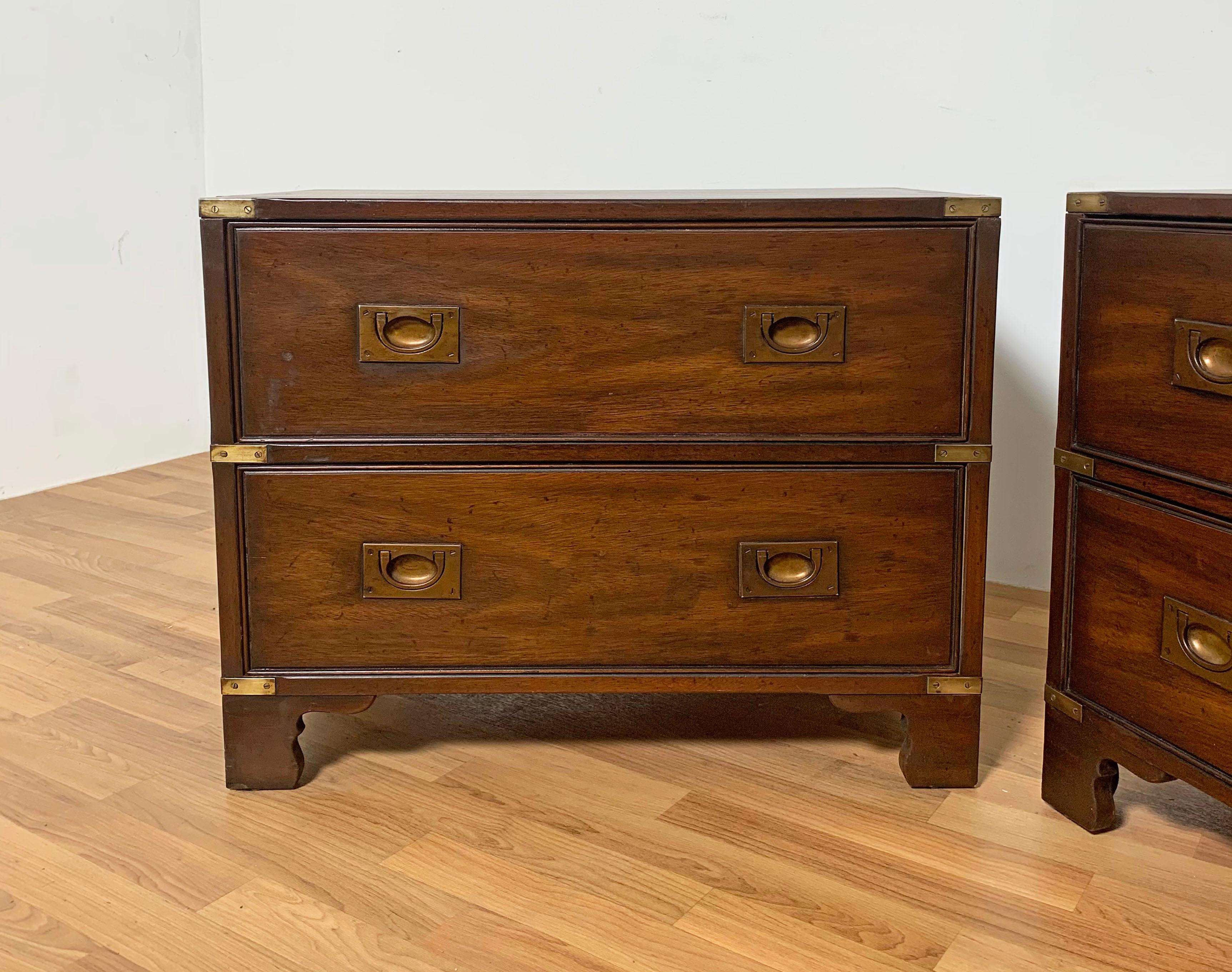 A pair of campaign style nightstands in walnut with brass hardware accents by Heritage Henredon, ca. 1960s.