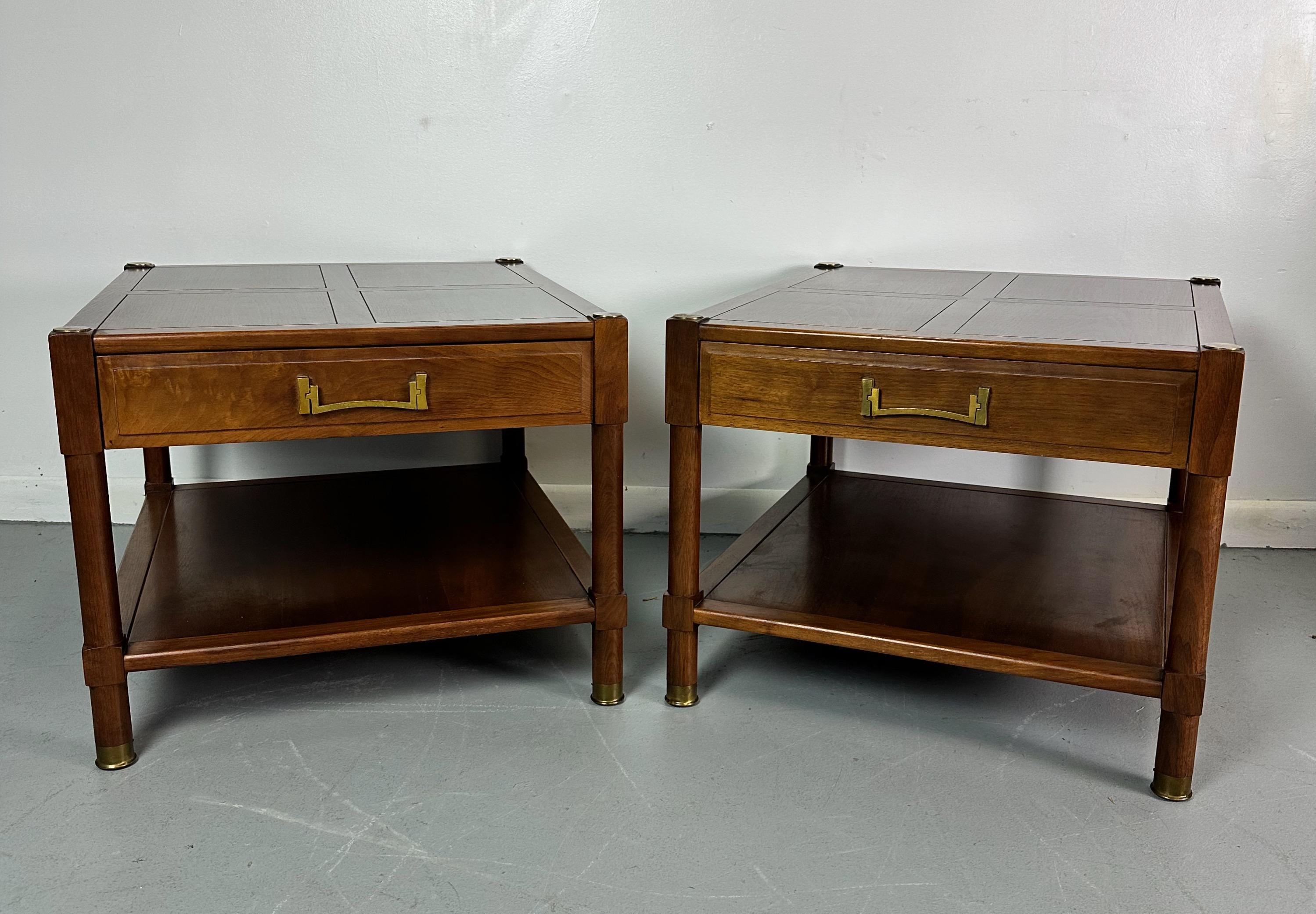 Sophisticated pair of walnut nightstands that have been designed with a bit of an asian flair. These wonderful pieces are crafted out of beautifully grained walnut and accented with brass fixtures and pulls. 