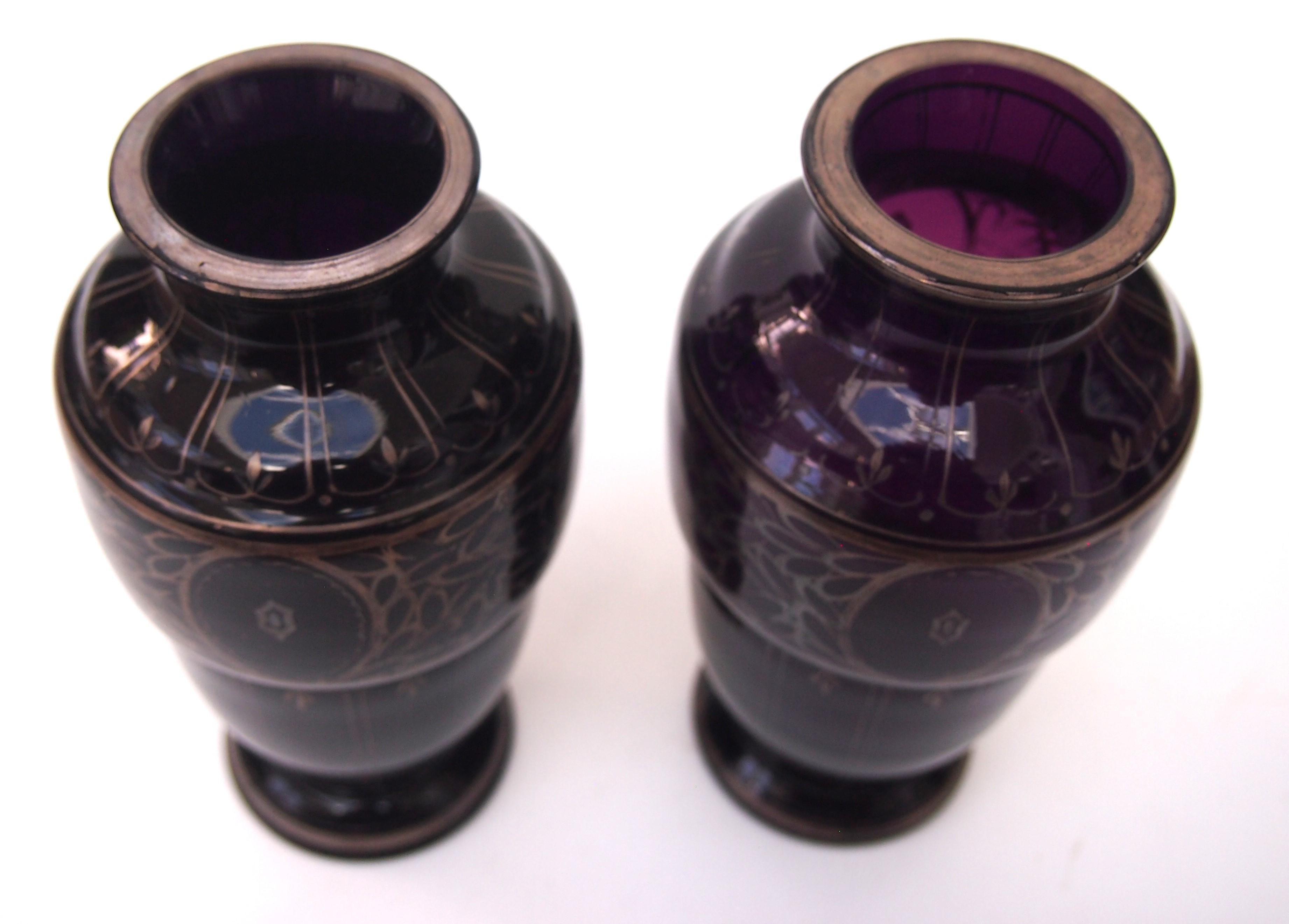 Rare paire de vases circulaires de forme balastre Herman Eiselt Dark Purple rehaussés d'une très fine couche d'argent dans un motif art nouveau stylisé (veuillez noter que la couche d'argent est négligeable). 

En raison de sa faible épaisseur, la