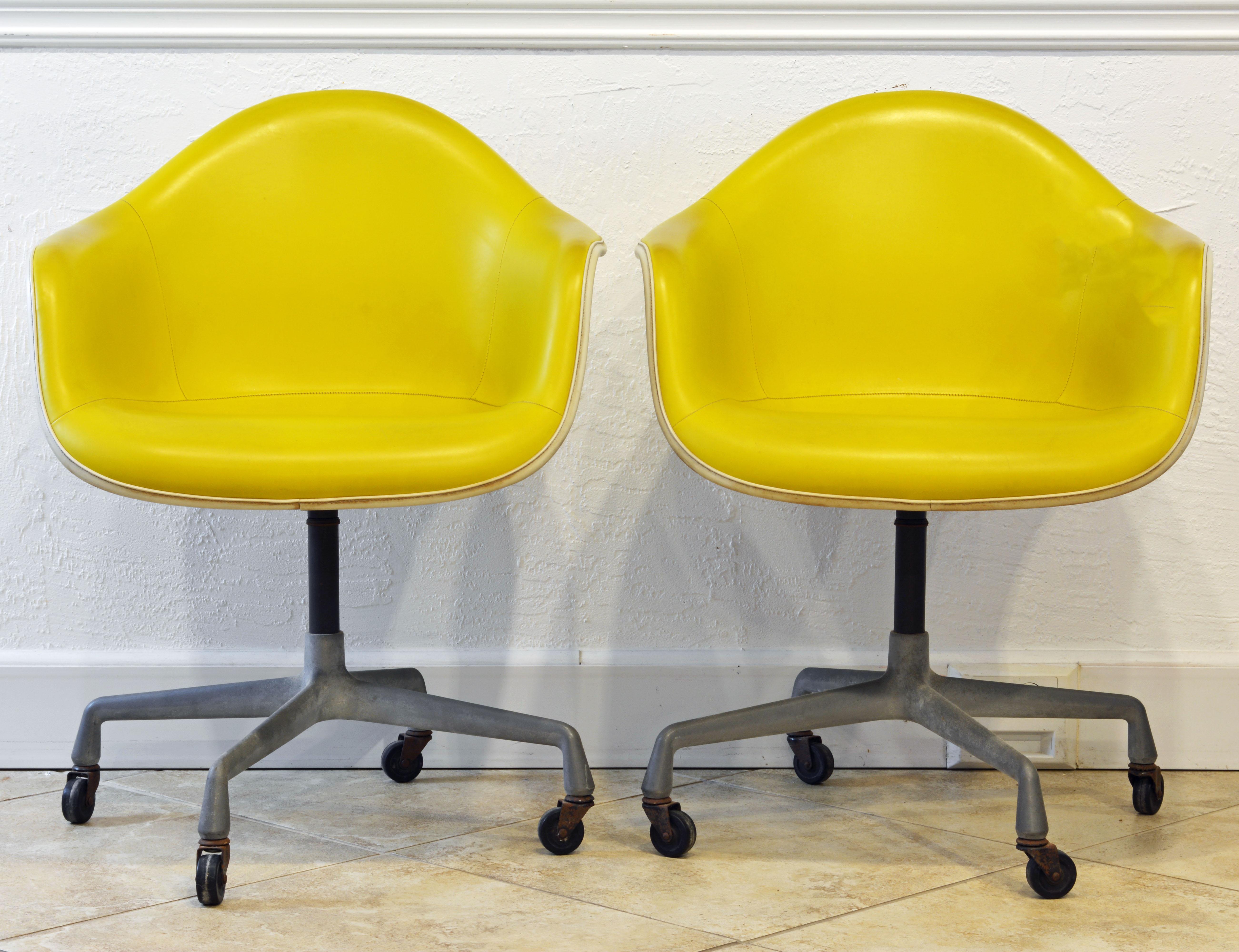 An iconic Mid-Century Modern design by Charles and Ray Eames for Herman Miller. The chair consists of a sculptural fiberglass shell with the interior upholstered and covered with stitched vinyl. The base is made of aluminium resting on wheels. The
