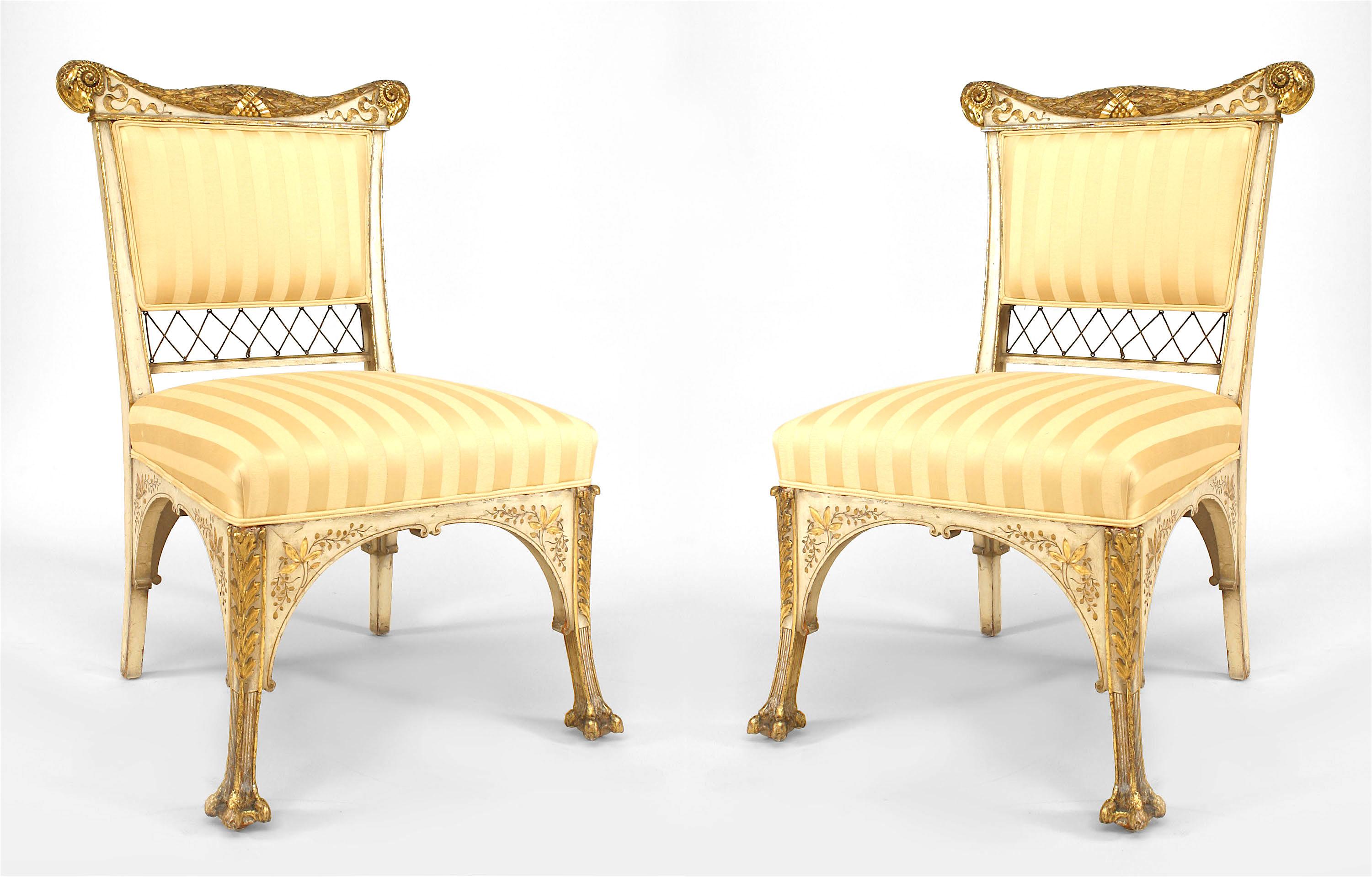 Attributed to famed nineteenth century American furniture designers the Herter Brothers, this pair of white-painted side chairs feature striped upholstery,  carved and gilded backs with lattice bottoms, and intricately carved, clawfooted parcel gilt