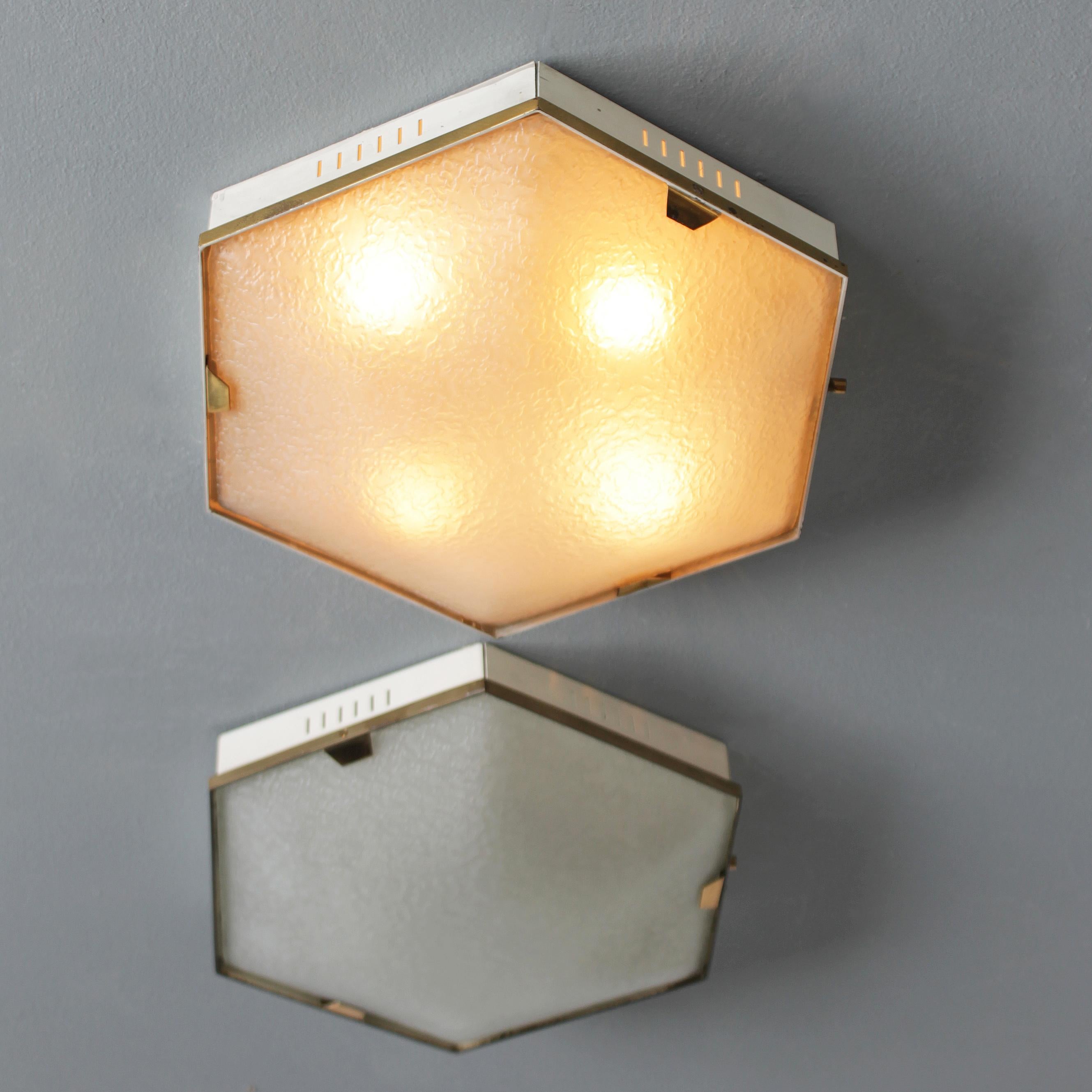 A set of two (2) hexagonal four light flush mounts or wall lamps by Stilnovo Milano, marked.
Stilnovo was founded in Milano by Bruno Gatta in 1946. Together with companies like Arteluce, Arredoluce and Fontana Arte, Stilnovo became one of the