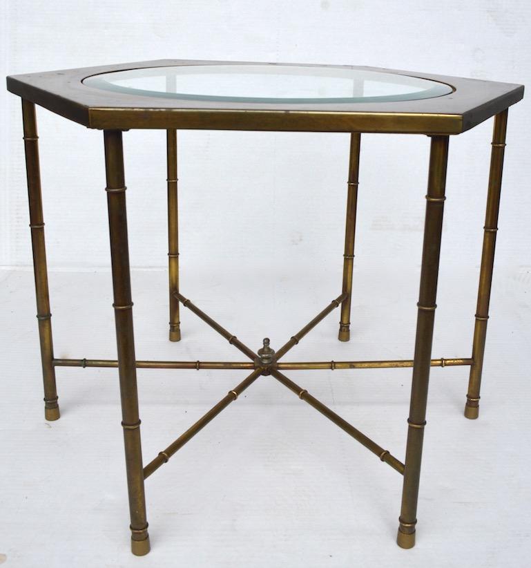 Decorative pair of hexagonal brass and glass tables with brass faux bamboo legs. Each table has a circular bevelled glass insert top, brass tops show minor cosmetic wear, normal and consistent with age.