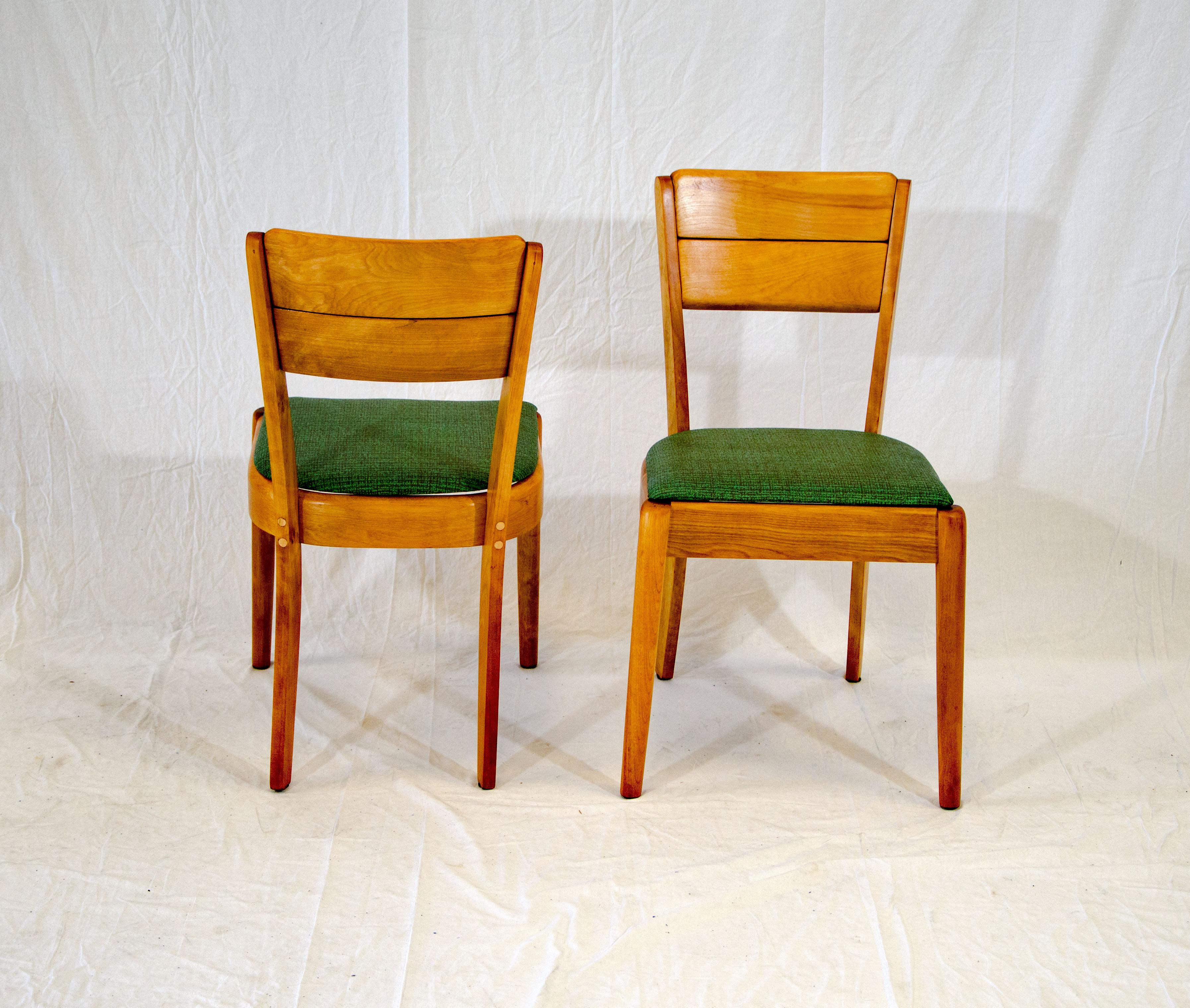 A pair of 1940s Heywood Wakefield dining chairs that would serve well at a small breakfast table or as desk chairs in a child's room. Produced from 1941-1944. The seats are easily detached to install different upholstery.