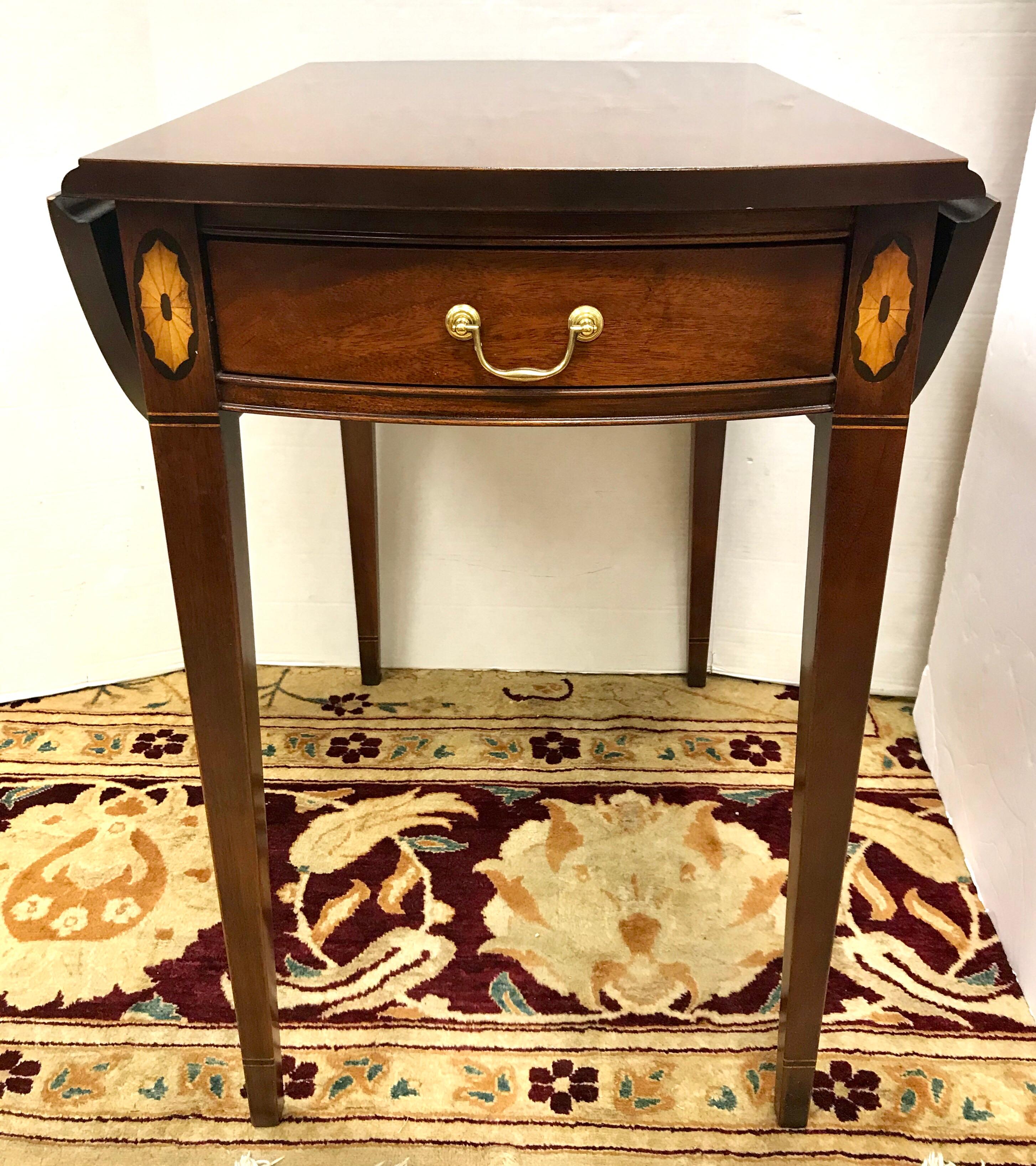 Pair of Pembroke one drawer drop-leaf tables work beautifully beside your bed, sofa or favourite chair. Leaves swing up into a broad oval, making extra space for glasses, books or projects. Solid mahogany with line and oval inlay and square tapered