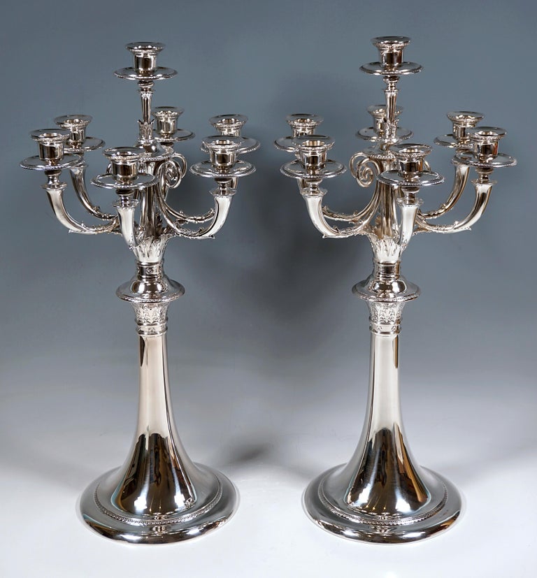 Two elegant seven-light candelabras on a round, trumpet-shaped raised foot with a palmette band on the foot and a stylized flower and acanthus frieze under the disc-shaped protruding bead ring, above it another frieze with stylized flowers and