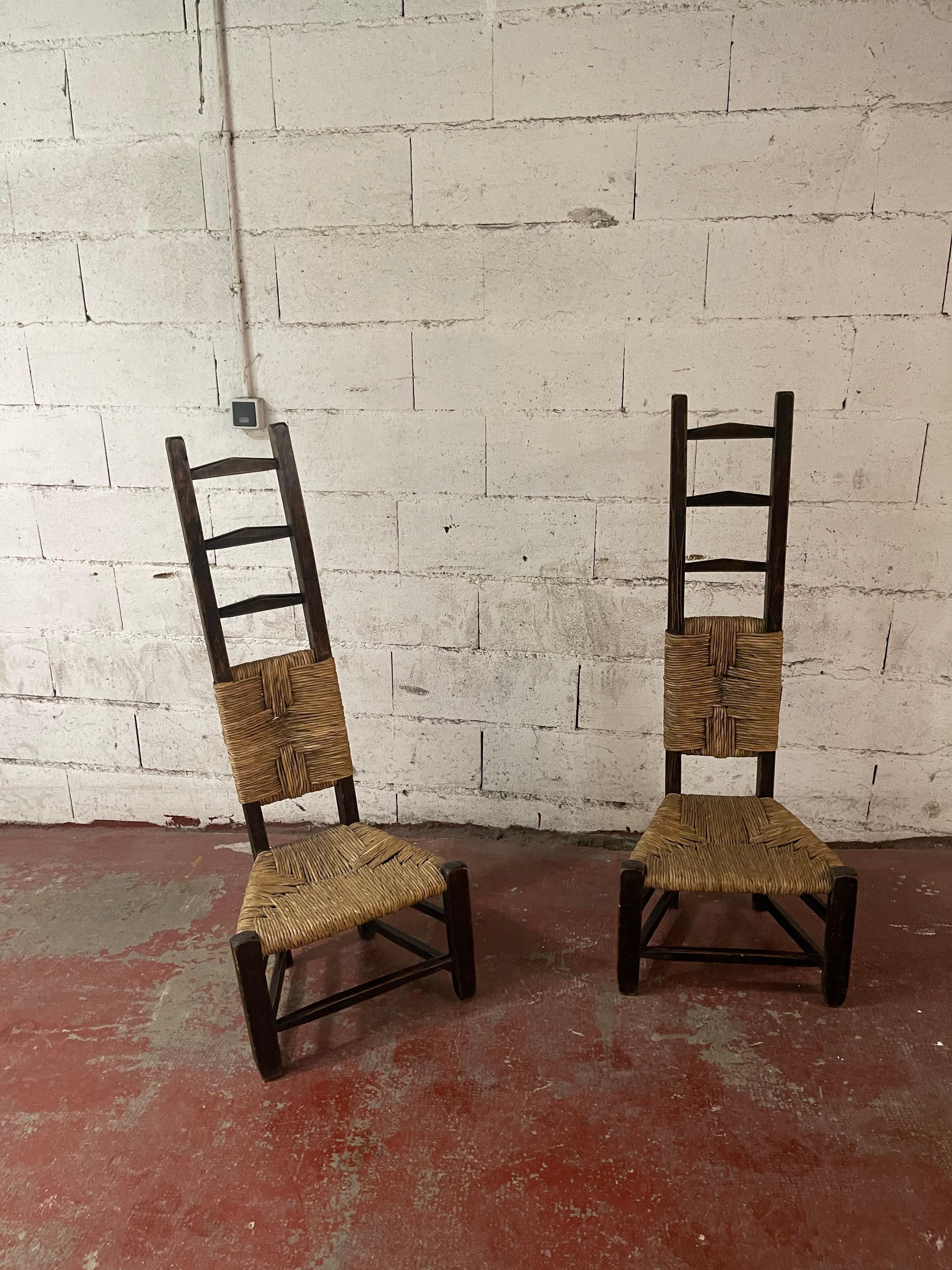 an amazing pair of high back chair in wood and straw.