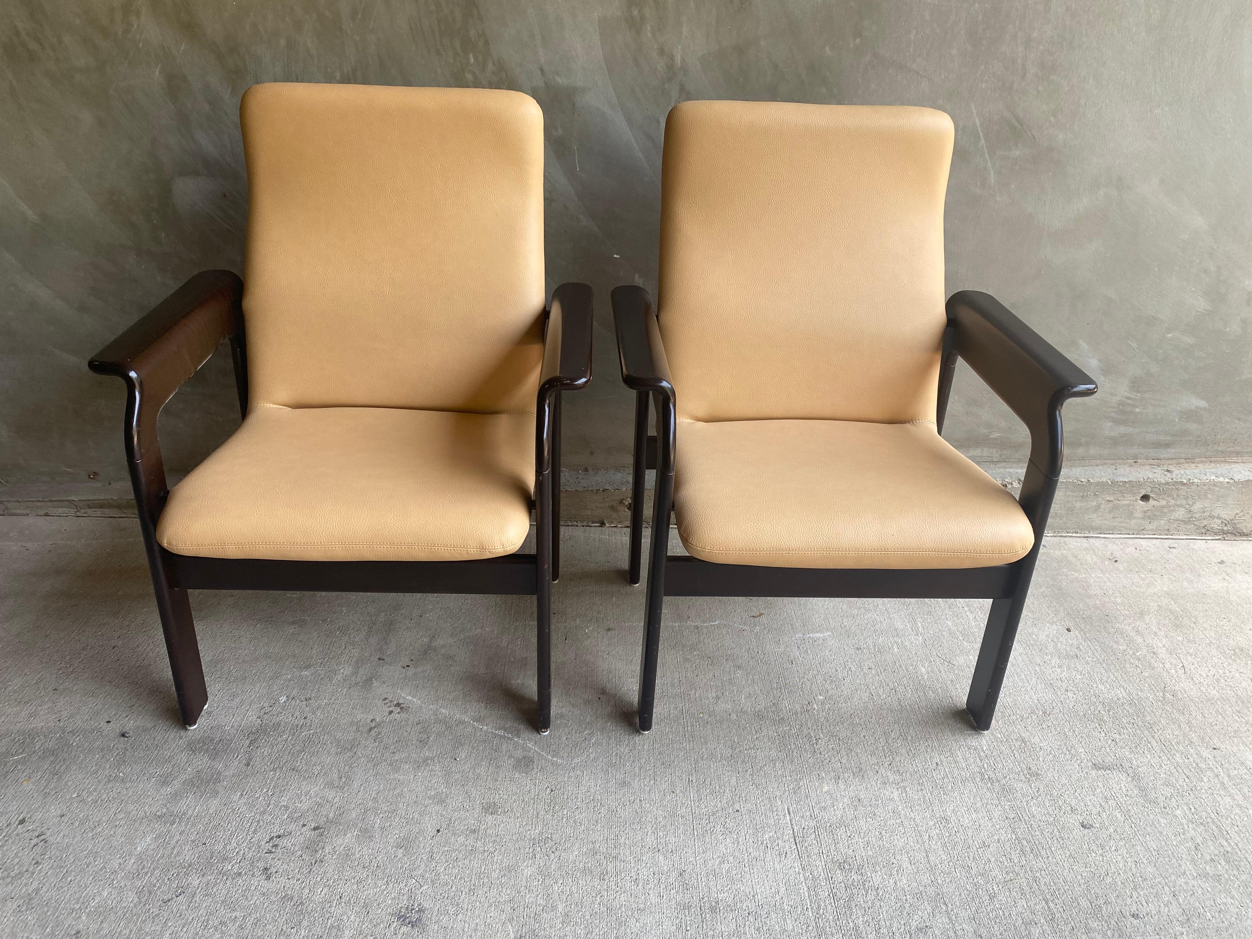 Pair of Scandinavian modern styled armed lounge chairs by Bruno Rey for Dietiker.  Designed in mid-1960's with continued manufacturing. Comfortable with generous proportions.  Due to more recent production, the leather is in beautiful condition.