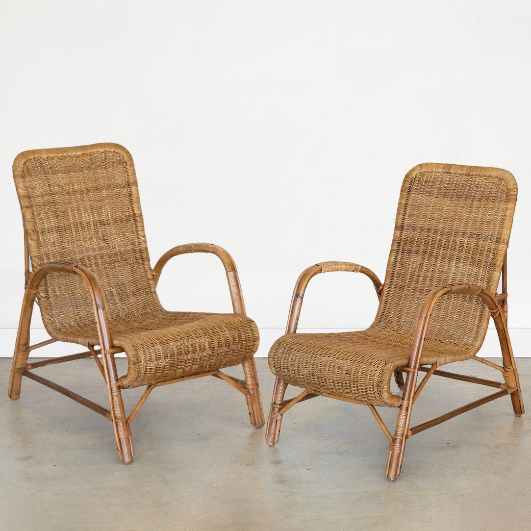 Incredible pair of sculptural wicker armchairs with high backs from Italy, 1960's. Woven wicker seats rest on rattan frame with wrapped rattan detailing. Beautiful green rattan detailing on arms. Stunning statement chairs.