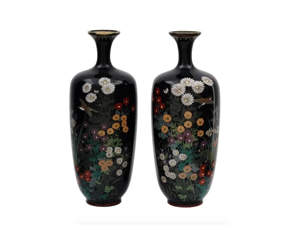 A beautiful pair of high quality antique Japanese Meiji Era brass and enamel vases, 1868 to 1912. Both are of a baluster form with elegant narrow necks slightly expanding to the rim. The exterior is enameled with nicely detailed polychrome images of