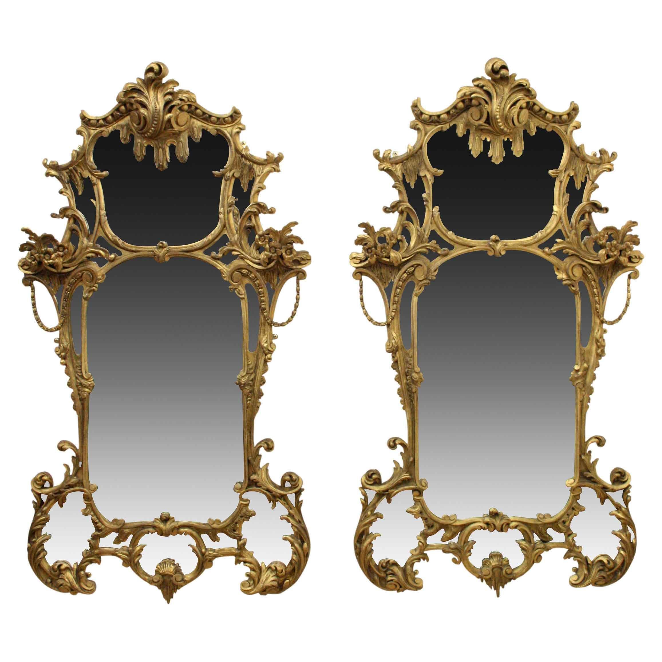 Pair of very stylish high Rococo style gilded mirrors, circa 1860. The mirrors comprise of several small mirrors, each enclosed in a carved wood and gilded frame. The top is surmounted with a wonderful foliate carving with a stylised pediment on