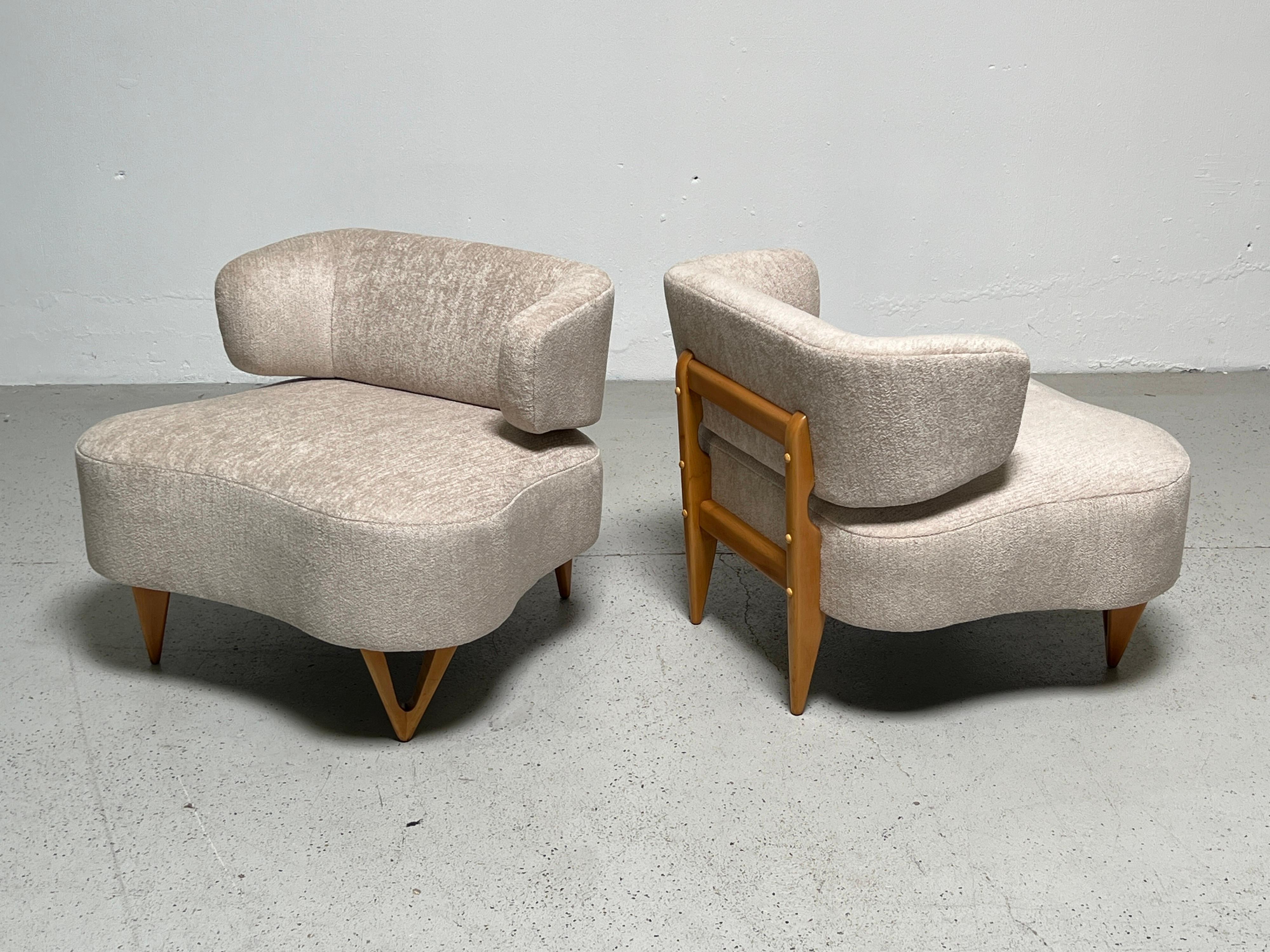 A pair of high style armless lounge chairs with sculpted legs. Fully restored and reupholstered in Holly Hunt fabric.
