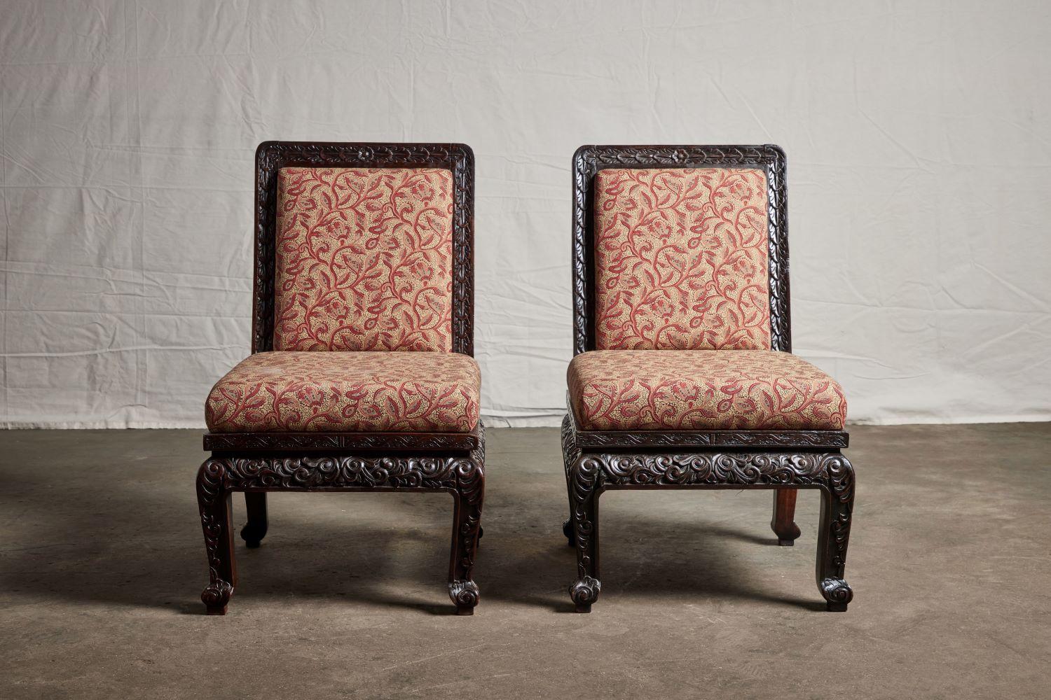 Pair of highly carved Asian slipper chairs from 1900.