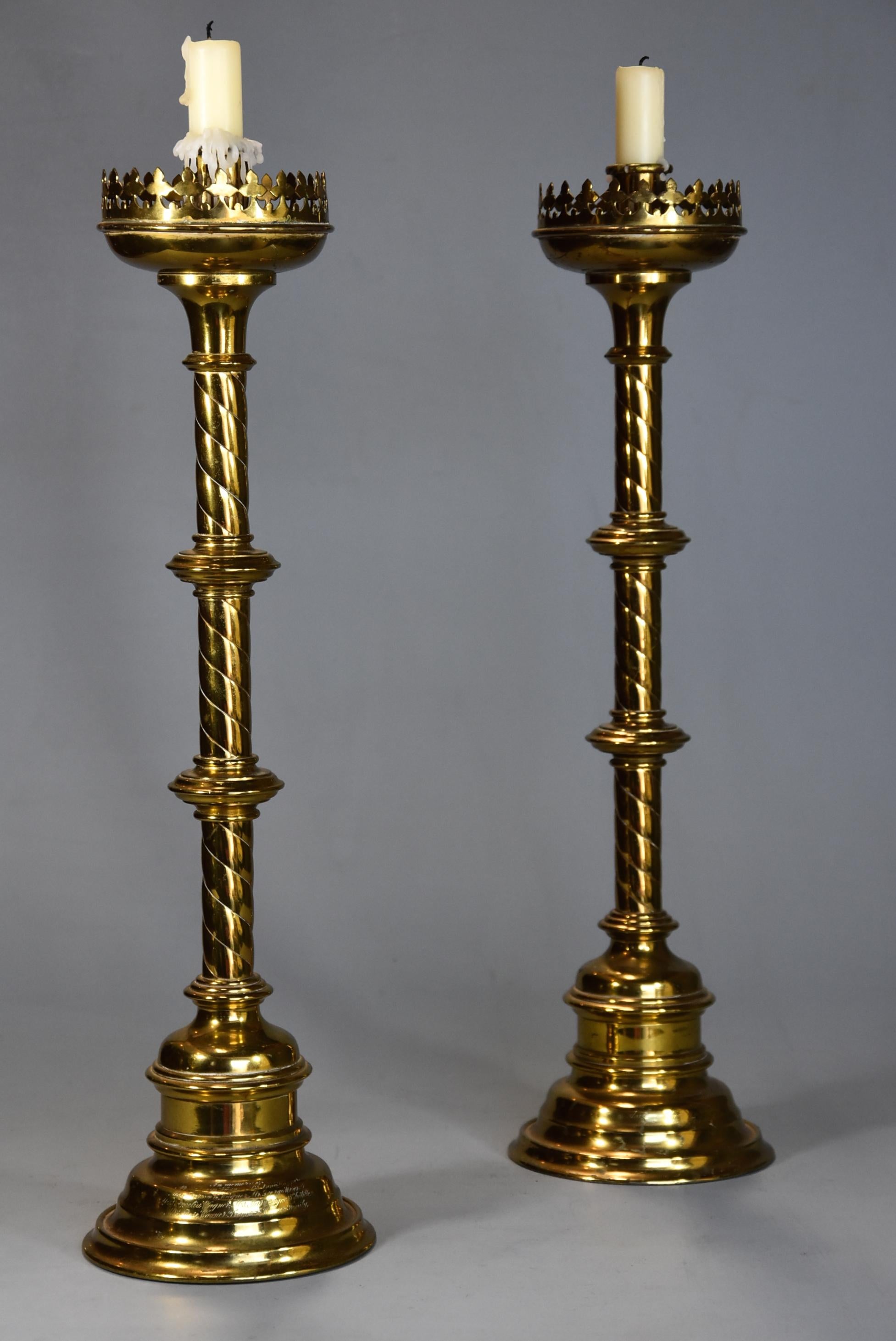 A pair of highly decorative late 19th century Gothic style brass candlesticks.

The candlesticks consist of a candle holder to the top with a rimmed edge with a drip pan with a trefoil pierced gallery of typical Gothic design.

This leads down