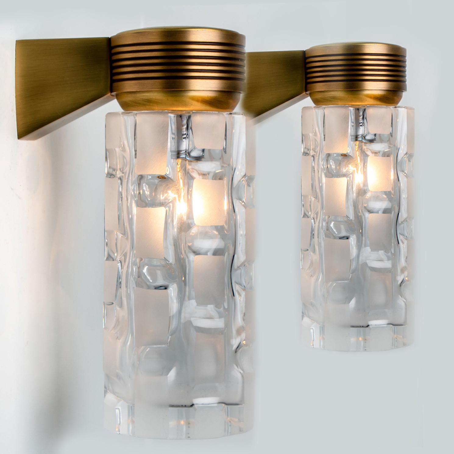 Wonderful high-end wall light fixtures manufactured by the german company Hillebrand, around 1970.
Clean lines to complement all decors. The lights have a brass base and thick clear and milk glass, filling a room with a soft, warm glow.

The wall