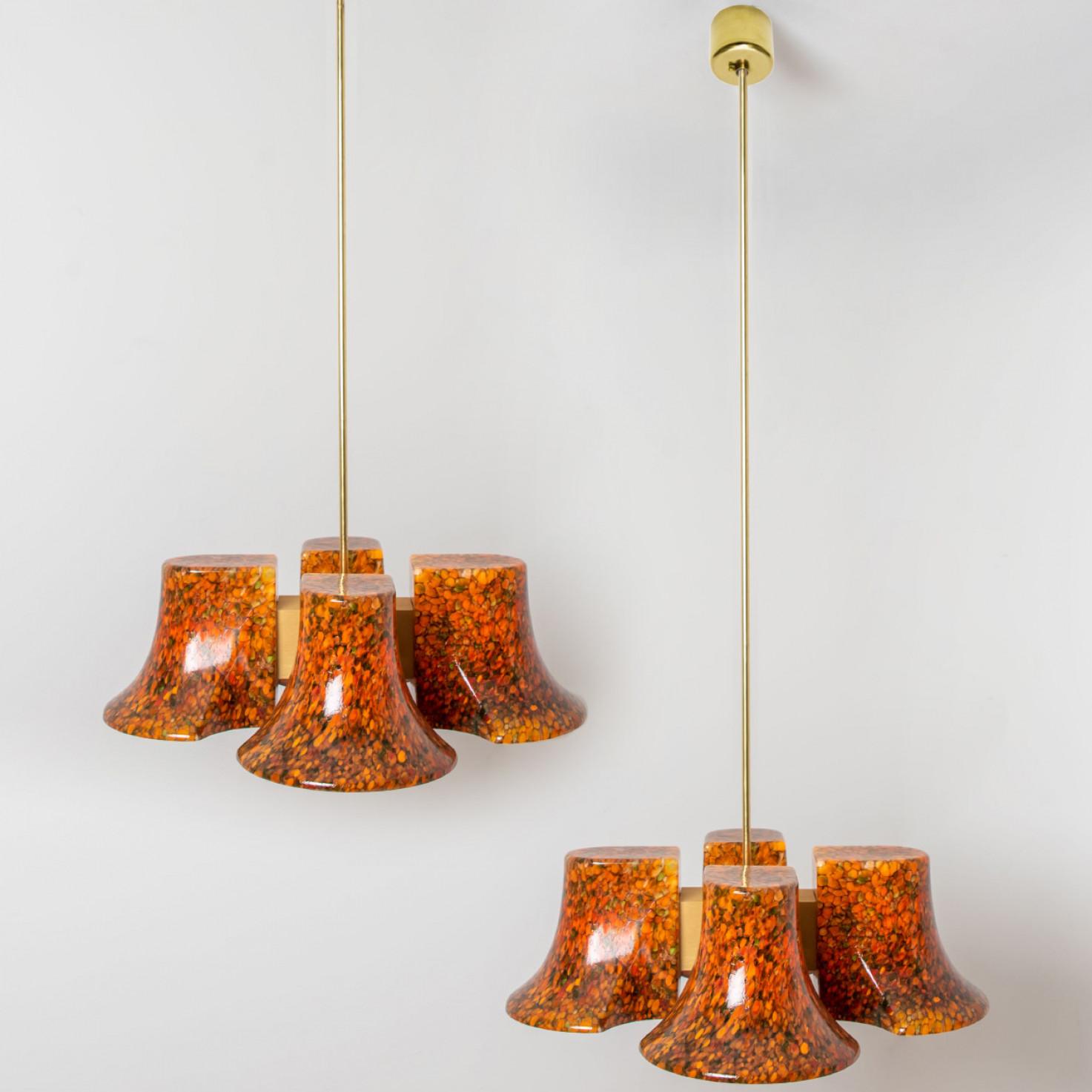 A pair of  fun and unique Hillebrand pendants made around 1970 in Europe.
The colors of the murano glass give the light a playful look. When lit, the pendant fills the room with a soft, warm color.

The pendant has a brass base and four murano glass
