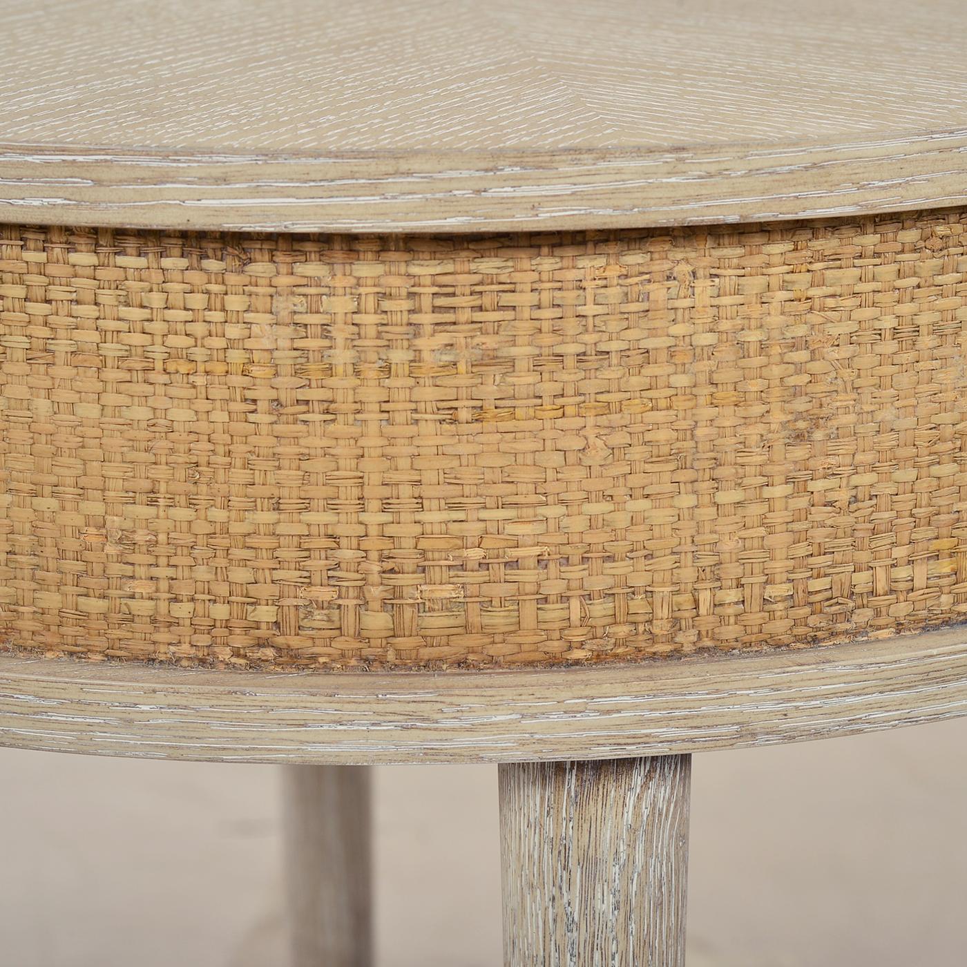 This elegant Coastal style table features the Himlaya finish, a round wood top with a raffia-wrapped apron, adding warmth and sophistication. The shaped stretcher connects its round, tapered legs, while slightly textured pewter finish ferrules