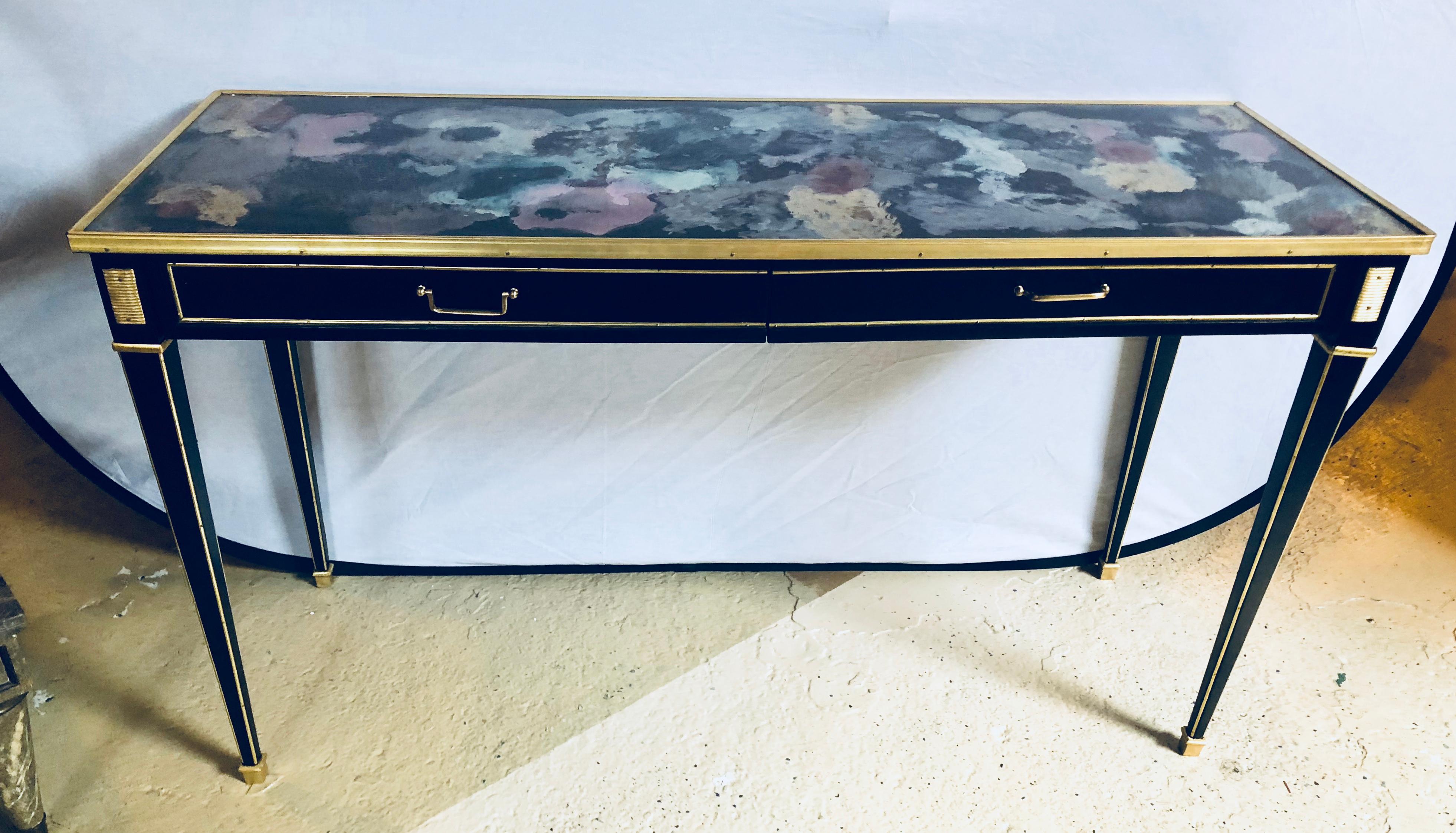 Pair of Hollywood regency style multi rainbow colored mirrored top bronze-mounted console tables. Each of these custom quality console tables have a colorful mirrored tabletop framed in a bronze apron above two large drawers all bronze framed with