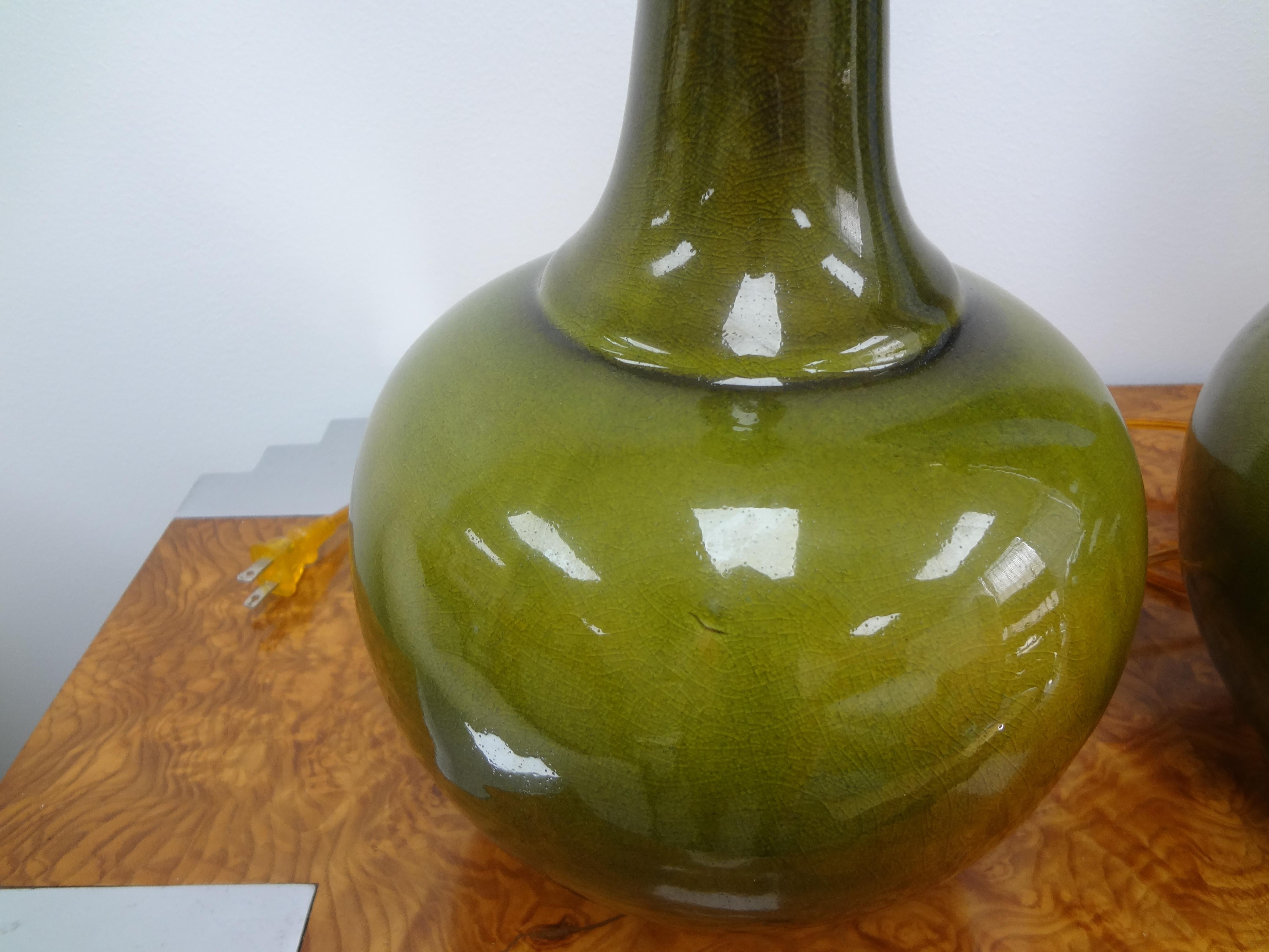 Pair of Hollywood Regency apple green ceramic lamps. This gorgeous pair of Vintage Hollywood Regency lamps are newly wired, come with their original matching finials and are ready for your choice of shades.