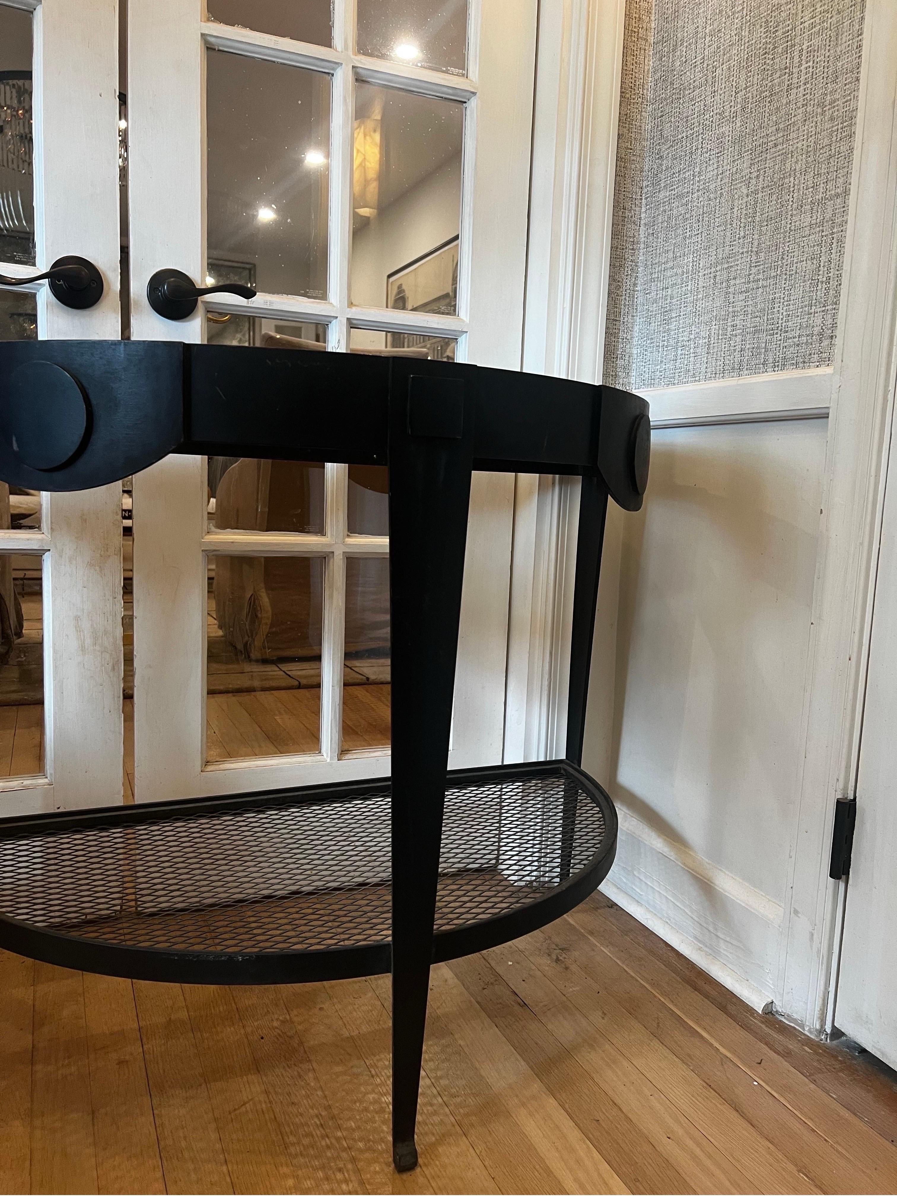 Pair of Black Iron Dem-lune console tables.   These would be great for a sunroom or entryway.  

Solid metal.  They do currently need glass top inserts. We put a temporary fiberglass piece in them as one may also decide on a stone/marble top.  