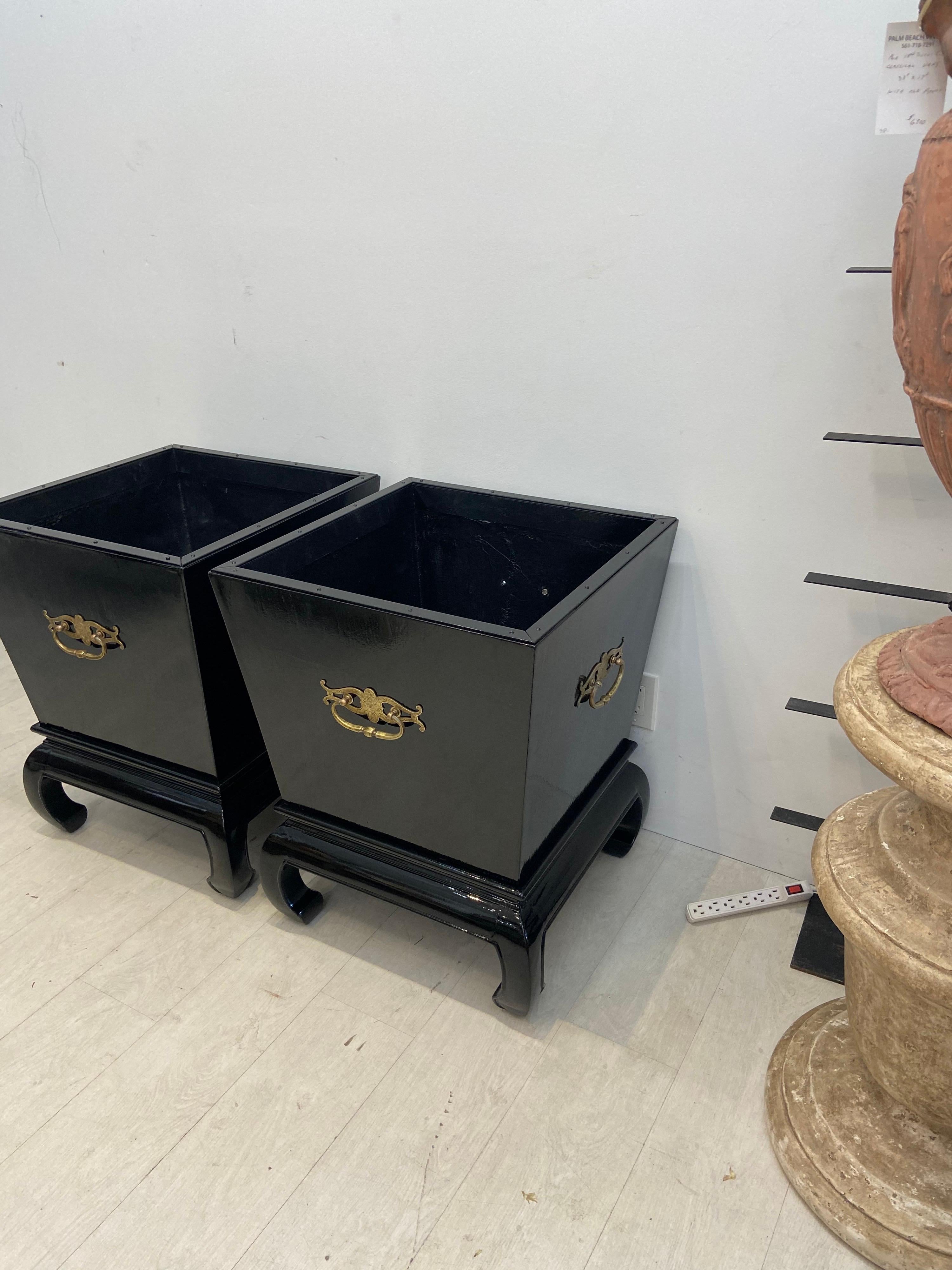 A Monumental pair of black lacquered Chippendale style planters… Each with four sides with applied decorative brass handles in the Chinese style. On a raised base with scrolled feet…