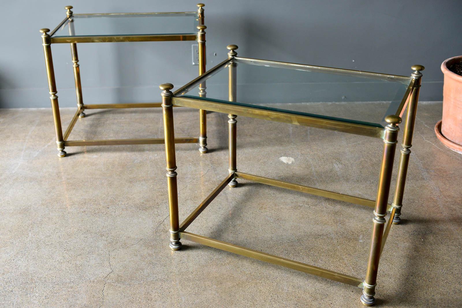 Pair of Hollywood Regency brass and beveled glass side tables, circa 1970. Glass is in excellent original condition with very light wear, no chips or cracks. Brass frames have wonderful warm patina.

Each measure 28