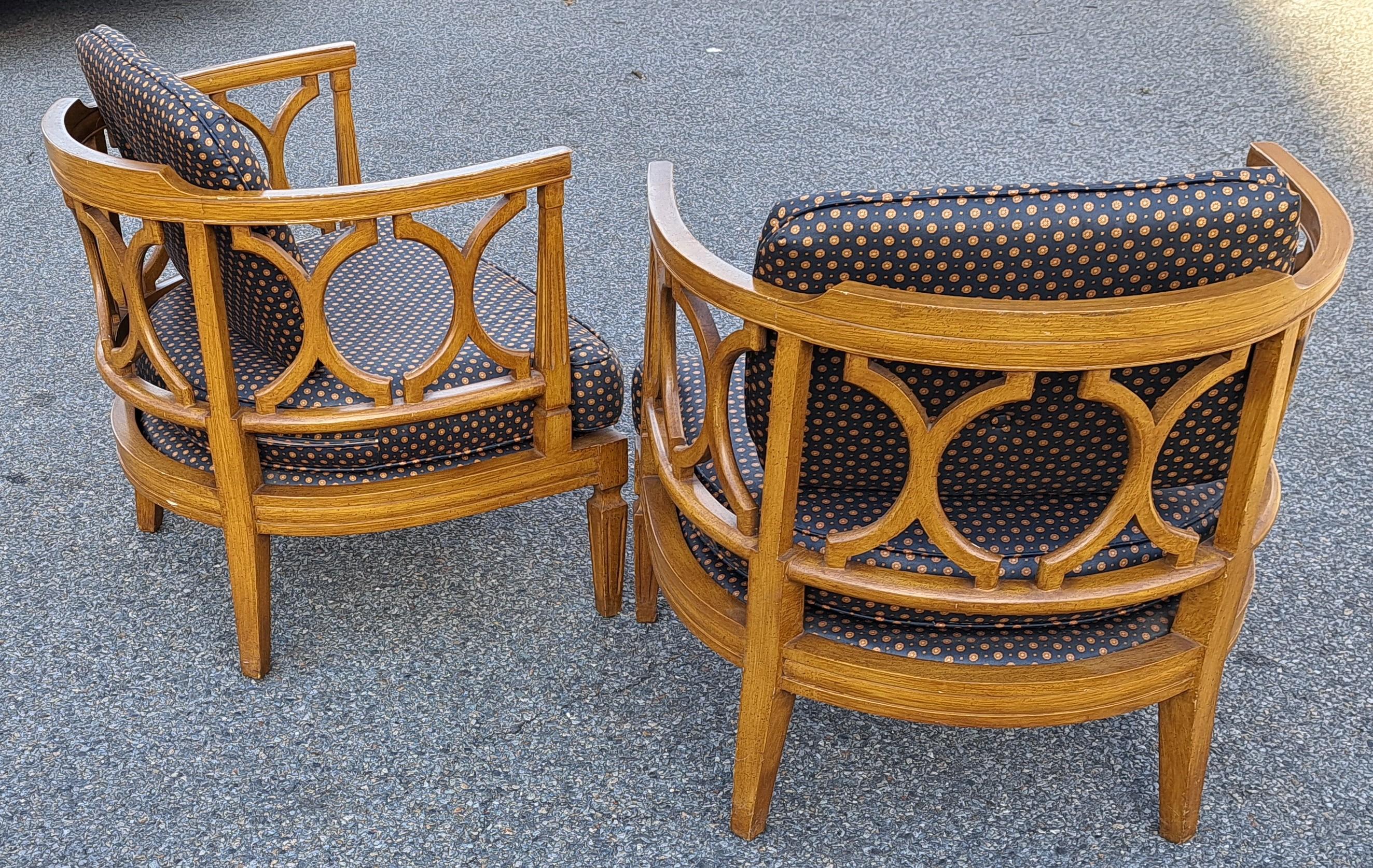 Pair of Mid-century Hollywood Regency barrel chairs with carved curve backs and dark patterned custom cushions that lend to a sophisticated glamourous look.