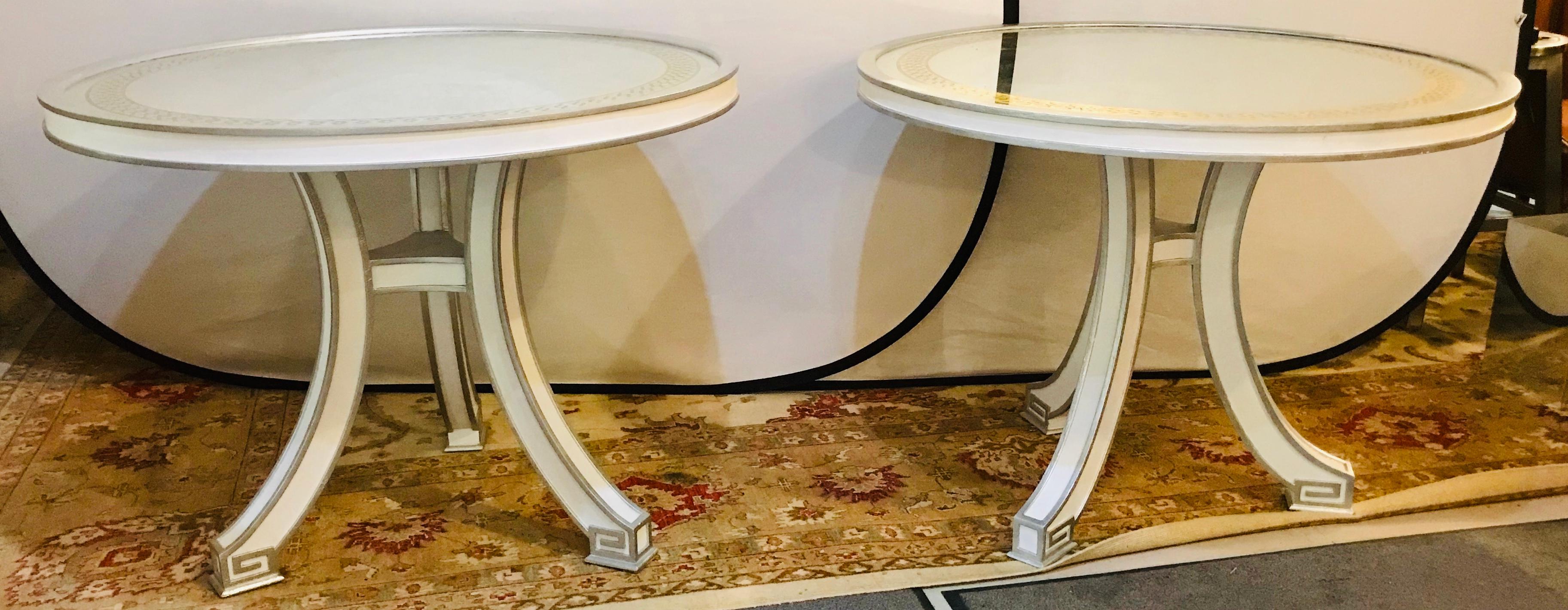 Pair of compatible églomisé top painted side end or centre tables. Each of these fine custom quality end table have an églomisé glass mirror form tabletop with a cross boxed gilt design border on a base of linen or off white gray design with parcel