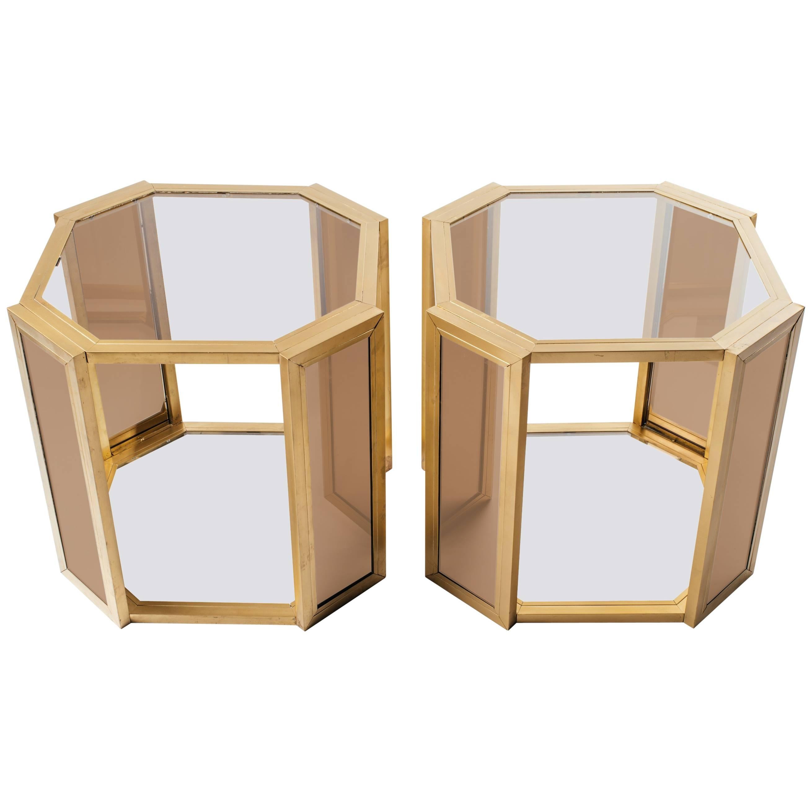 Two-tier Hollywood Regency side tables with hexagon form. Comprised of dark brass frames with smoked grey glass tops and fitted with smoked mirrored insets on all legs.