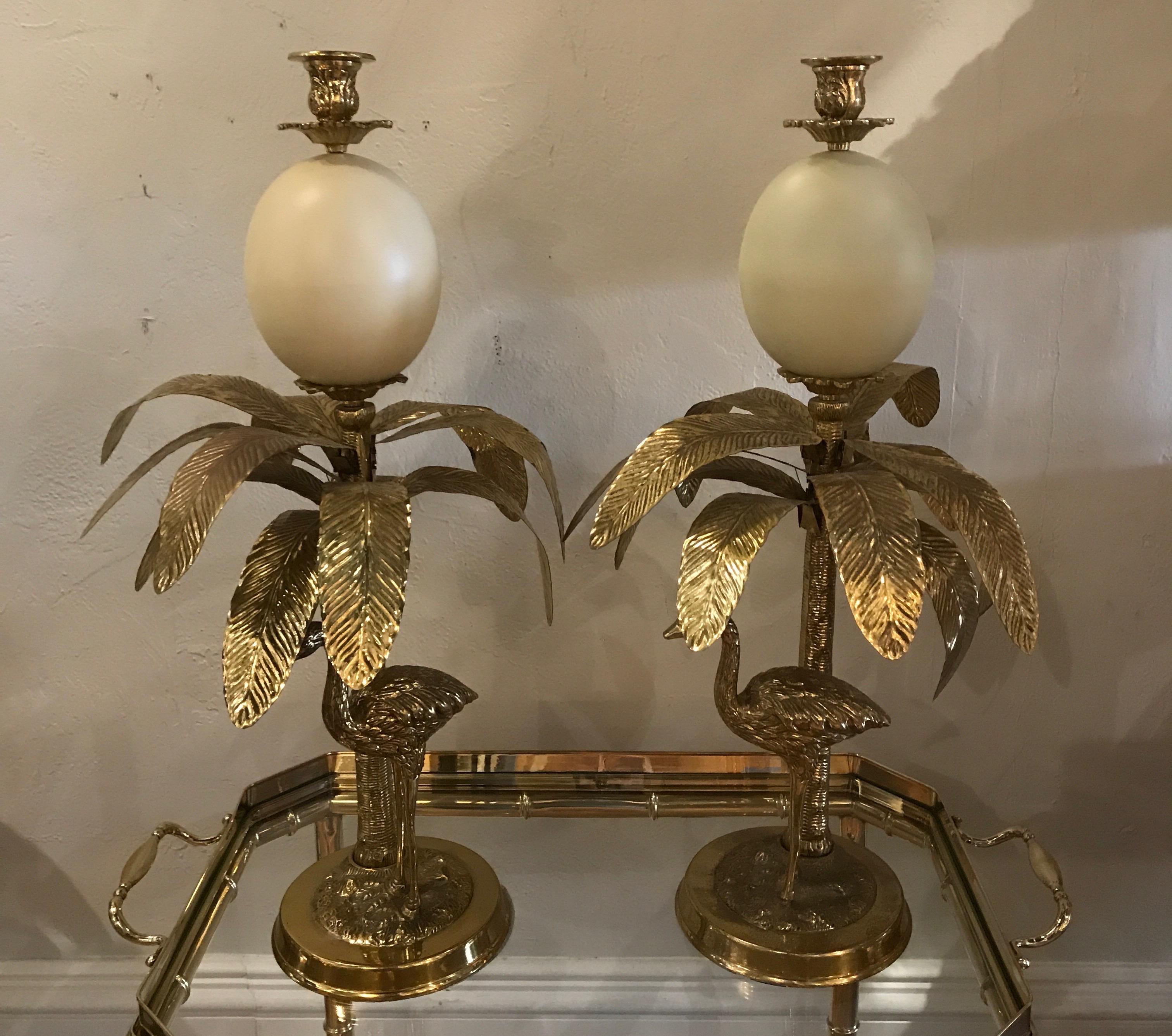 Pair of faux ostrich egg, ostrich & palm tree brass candlesticks in the Hollywood Regency style.