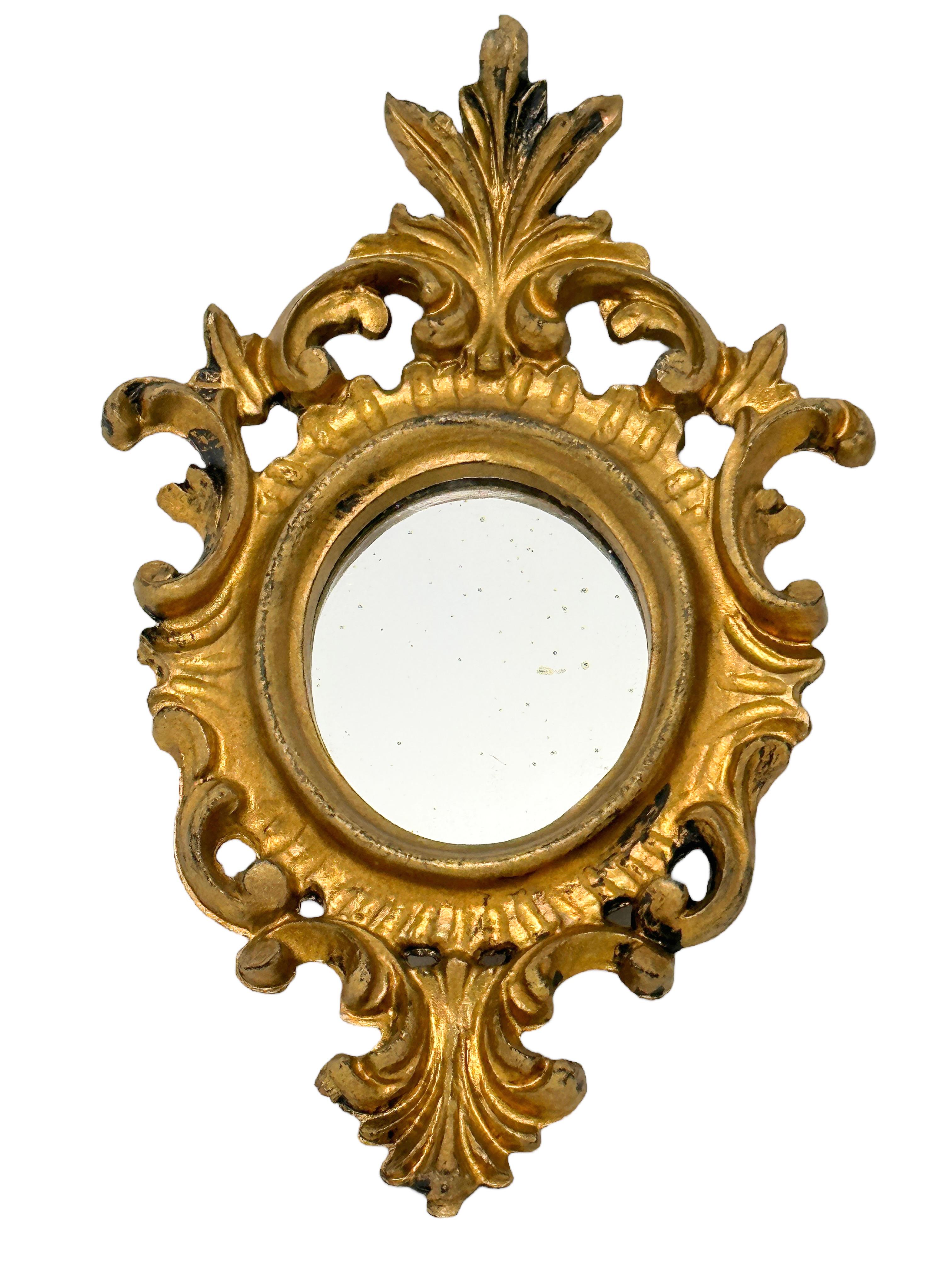 Stunning pair of Hollywood Regency style toleware mirror. The gilt frame surrounds a glass mirror. Made in Italy, circa 1950s. Beautiful small mirrors for any room. Nice addition to any room. marked Italy. viewable Mirror size itself is approx. 2