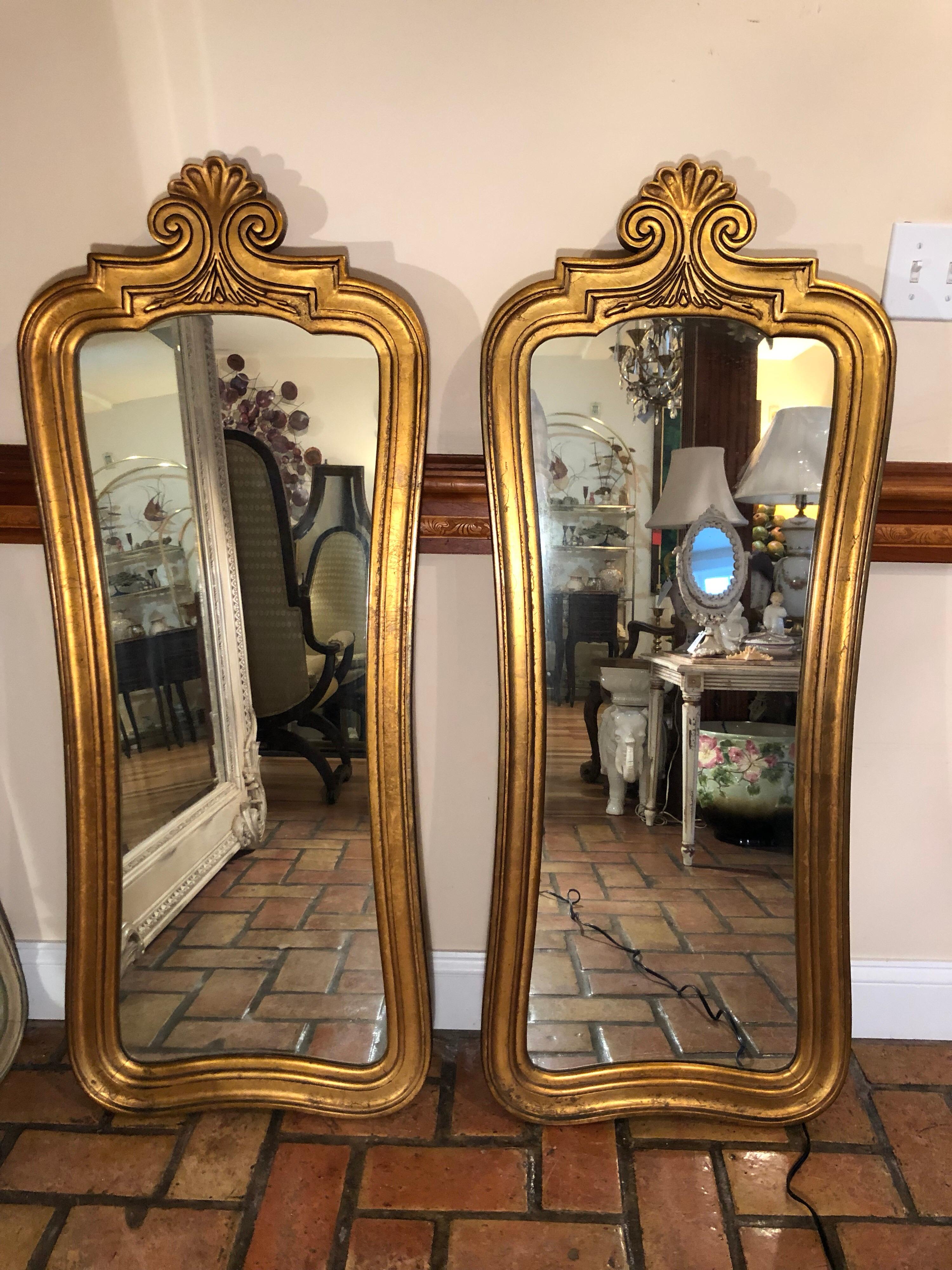 Pair of Hollywood Regency gilt mirrors. Classic design and perfect for that his and her bathroom. Nice heavy gilt patina with scroll work top. In very good condition. Please message us your zip code for a dealer parcel shipping rate that will be