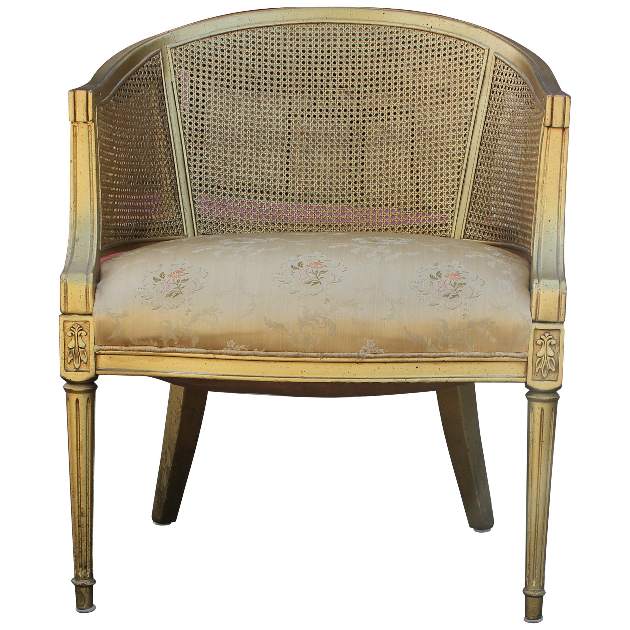 Pair of Hollywood Regency barrel back lounge chairs with gold cane and a gold wood frame.