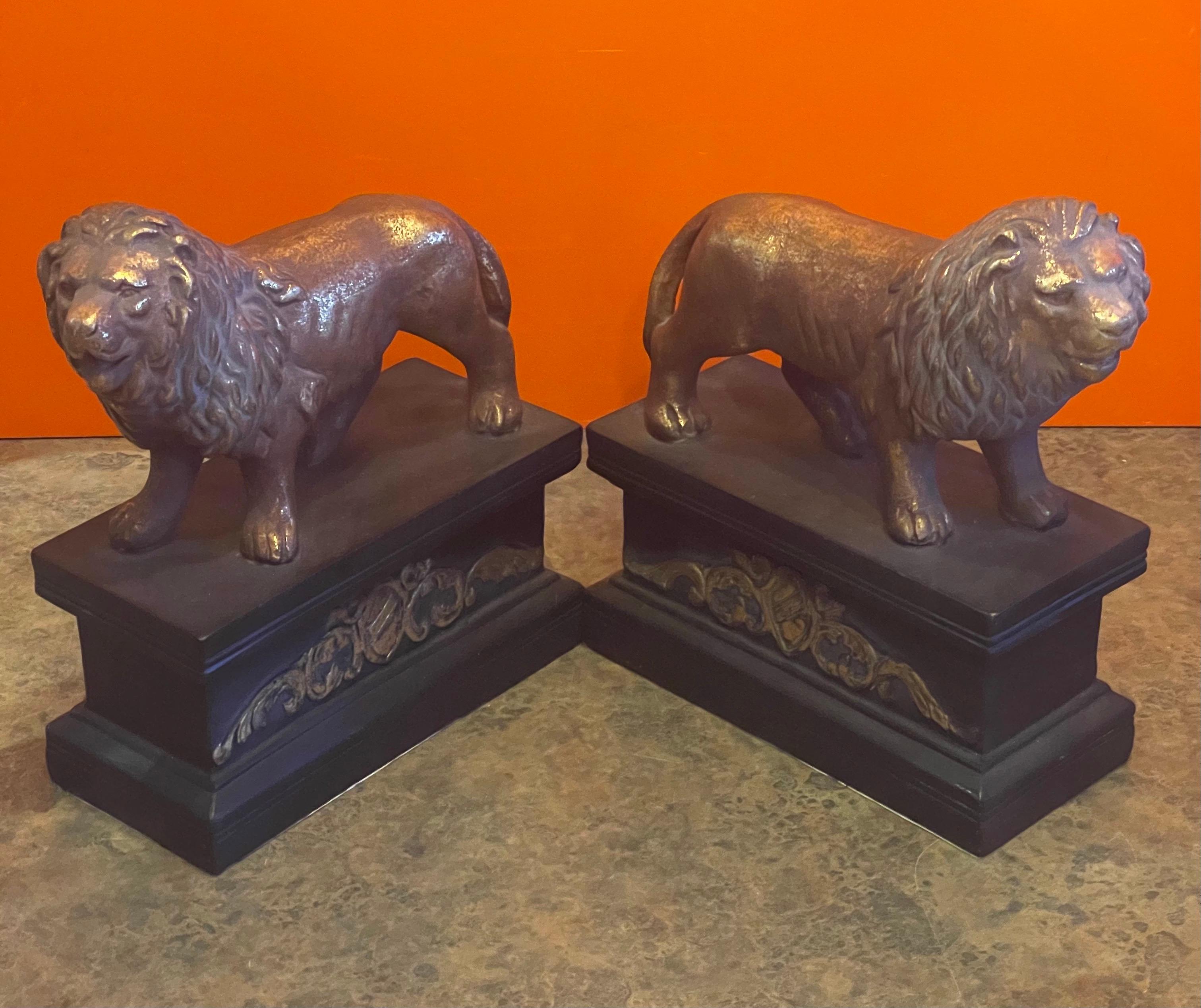 Stunning pair of majestic lion bookends in a gold gilt finish on a faux black marble base in the style of Borghese of Italy, circa 1970s. The pair is in great vintage condition and our made of cast plaster; each bookend is 8