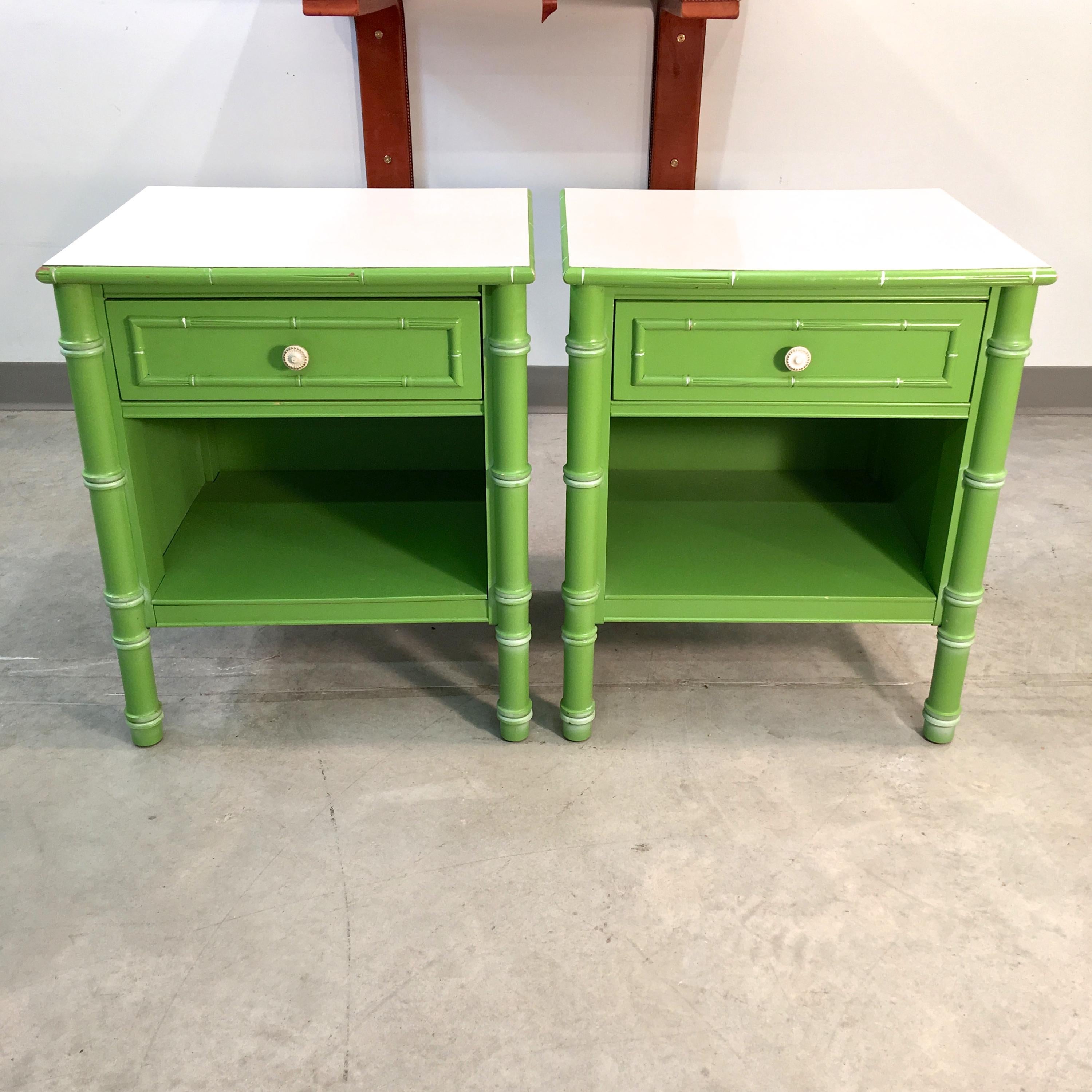 Pair of 1960s Thomasville Allegro faux bamboo nightstands in their original preppy pistachio green with striated white Formica tops. Each has a single drawer and an open storage space. They're closed off on the back.